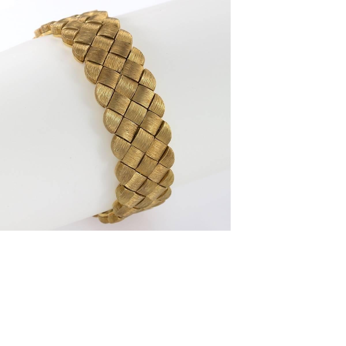 An American Late-20th Century 18 karat gold bracelet by Henry Dunay. The highly flexible bracelet is composed of a basketweave link pattern with Henry Dunay’s distinctive surface texturing and unique gold color. Unique Dunay slide clasp. Circa