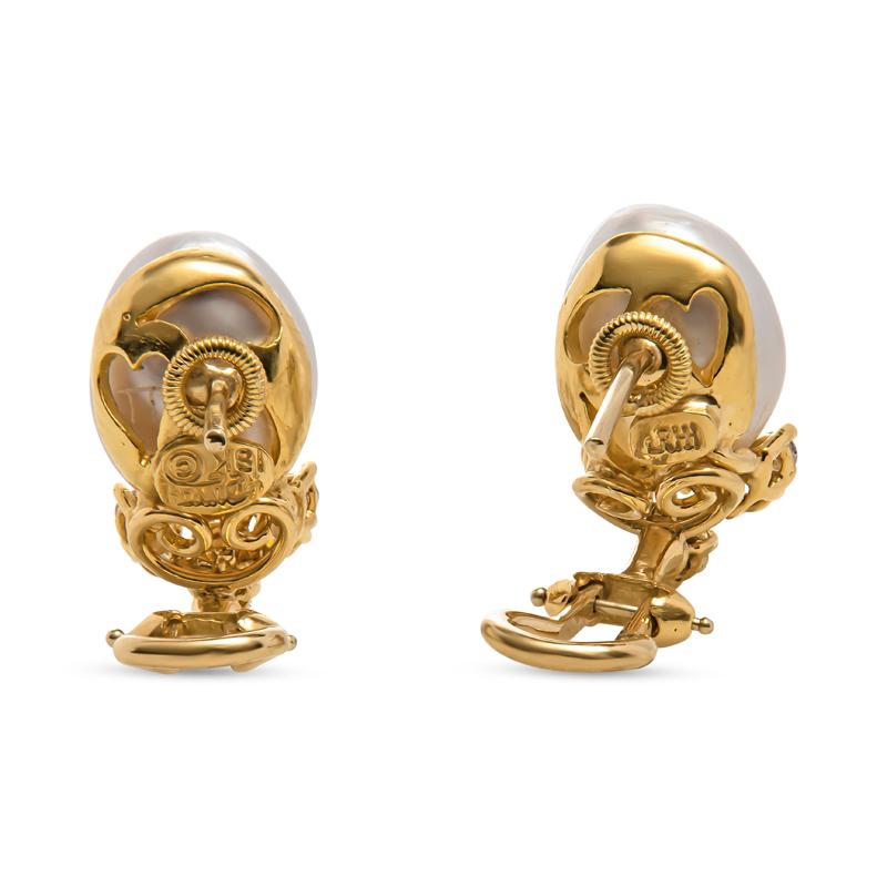 These vintage estate drop earrings from Henry Dunay feature Baroque cultured pearls accented by approximately 0.32 carat total weight in natural diamonds. They are set in 18 karat yellow gold with a post and omega back. Signed Dunay. 
Measurements: