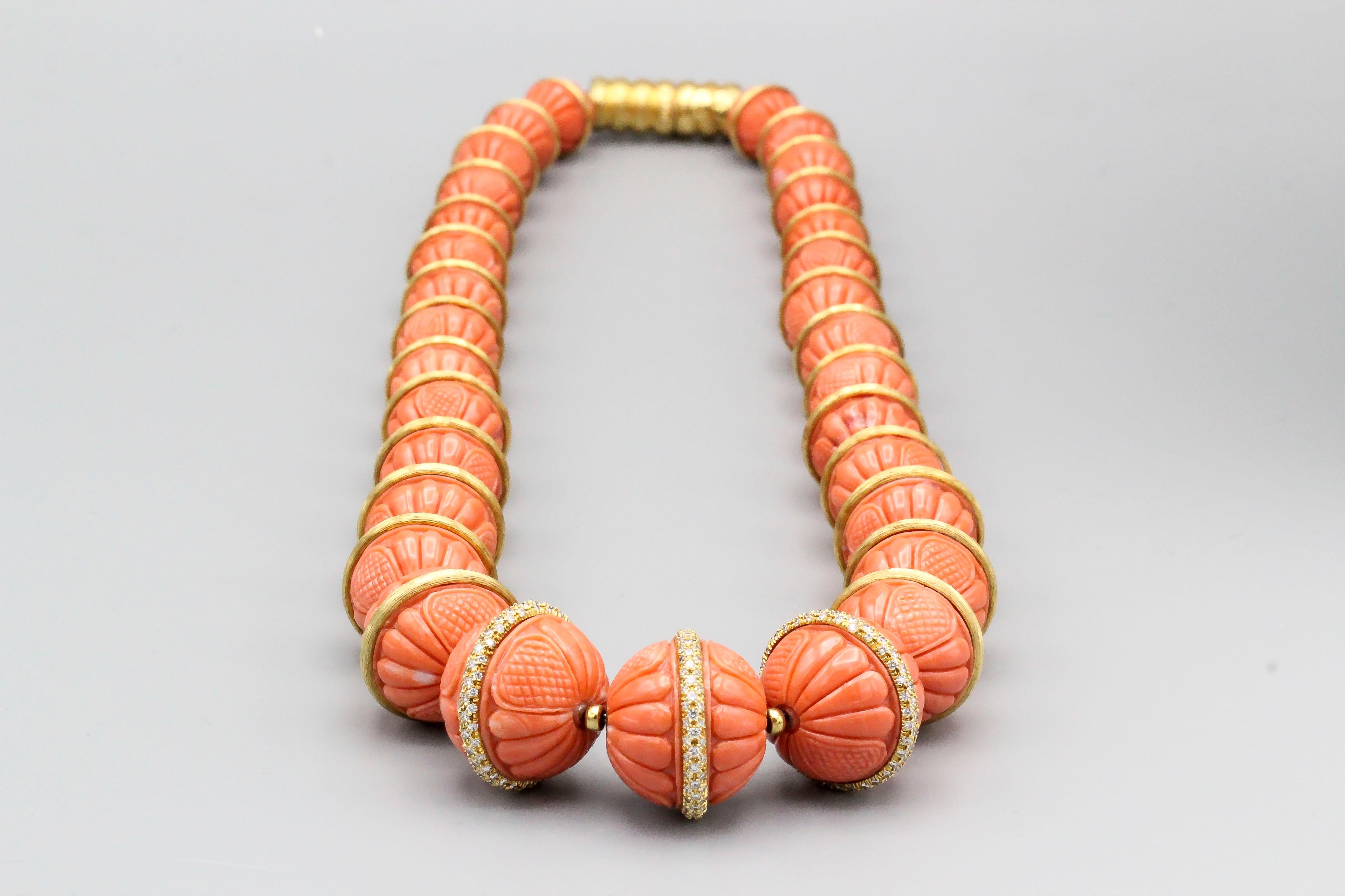 Impressive coral, diamond and 18K yellow gold necklace by Henry Dunay. The coral beads on necklace range in size from 11mm to 20mm in diameter. The corals are a rich salmon color and feature fine carvings on each bead; they are further accentuated