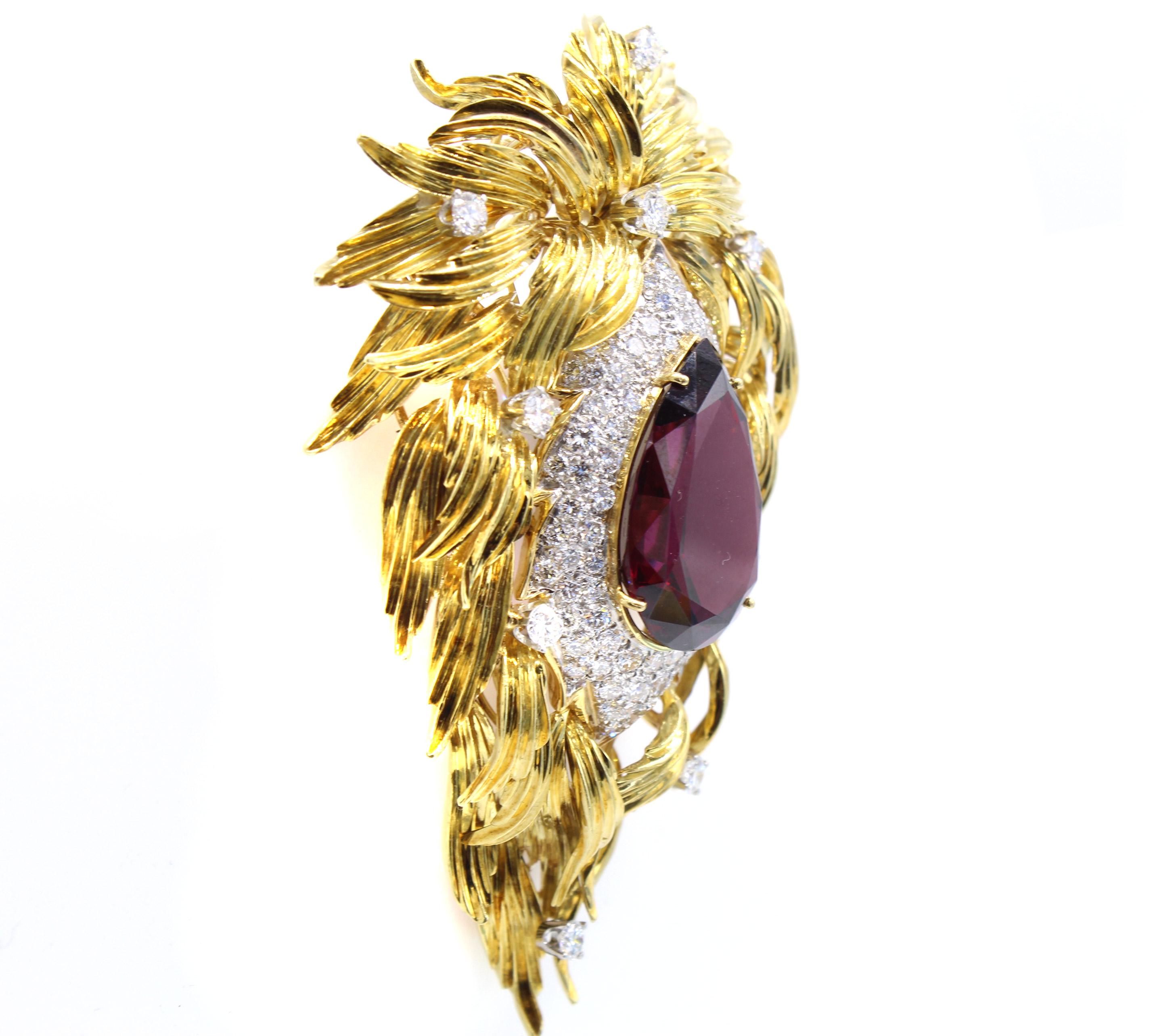 Beautifully designed and masterfully hand-crafted this unique and bold 1980s brooch by Henry Dunay features a pear-shape Rhodolite Garnet measured to weigh approximately 32 carats. Surrounding the center gem are 103 bright white brilliant cut