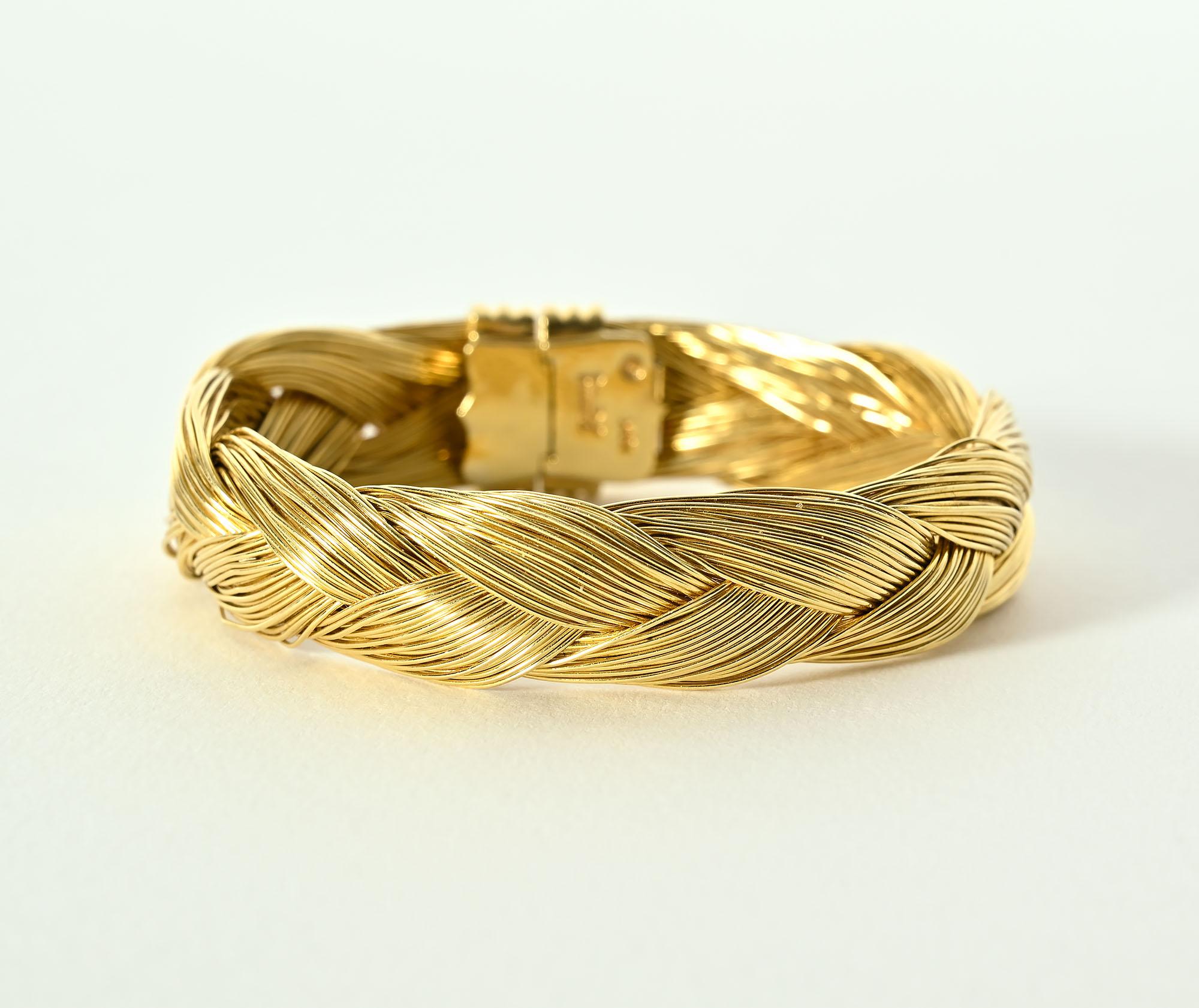 Geflochtenes 18-karätiges Goldarmband des amerikanischen Designers Henry Dunay. Das Armband ist einen halben Zoll groß.
Im geschlossenen Zustand beträgt der Innendurchmesser 2 1/8 Zoll.
Das Armband hat einen Zierverschluss, der entweder vorne