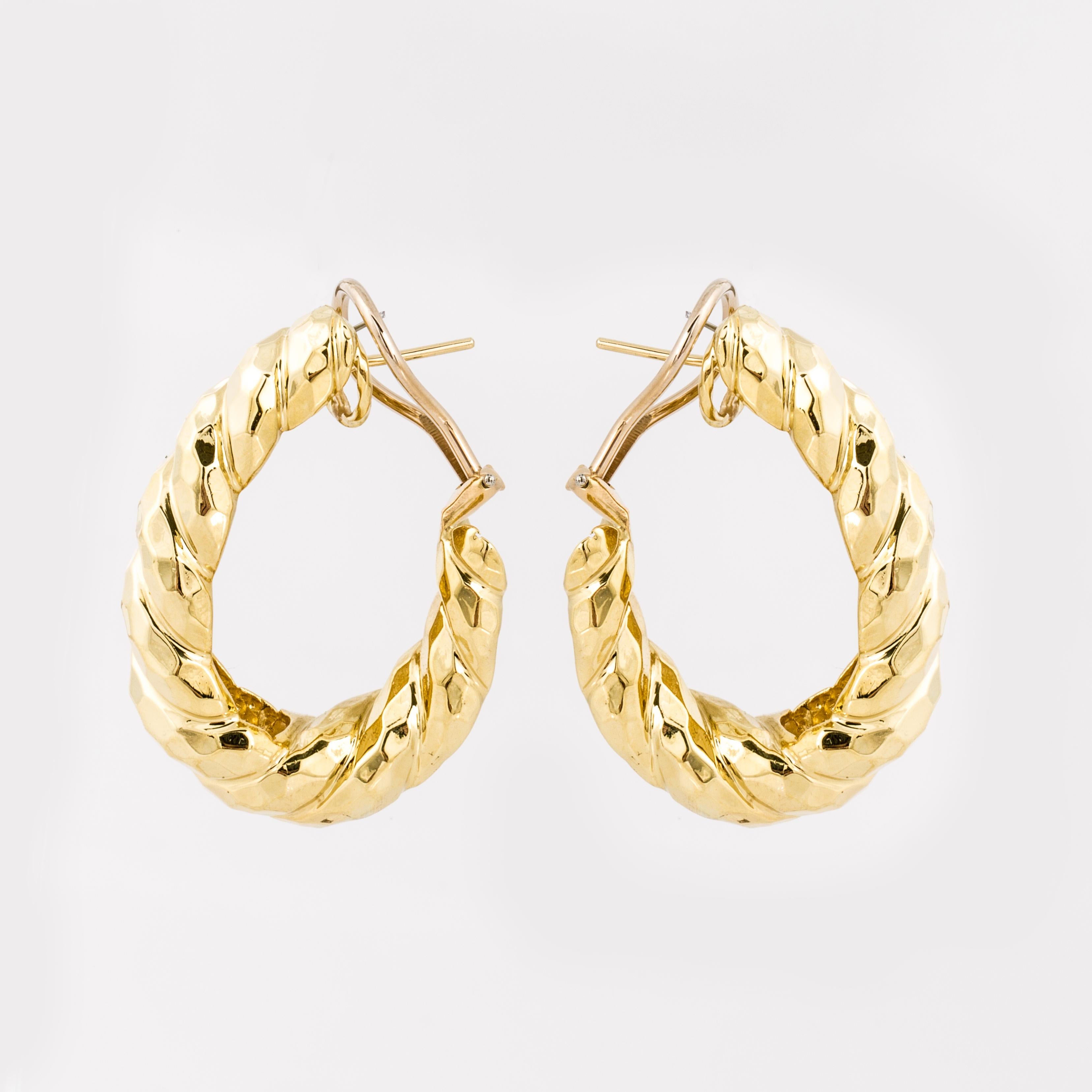 Henry Dunay hoop earrings composed of 18K yellow hammered twisted gold.  They measure 1 3/8 inches long by 5/16 inches wide and 1 inch deep.  The earrings have an omega clip back with a post.