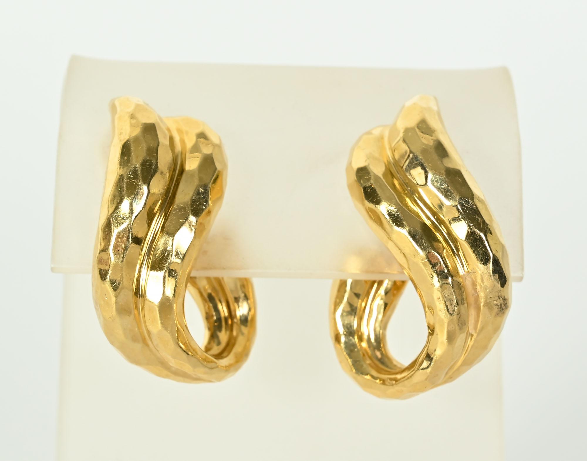 Large and graceful 18 karat hammered gold earrings by Henry Dunay. They have the hammered gold finish that he often used. The earrings have a lovely curvilinear design measuring 1 1/4 inches in length.
Clip backs can be converted to posts.