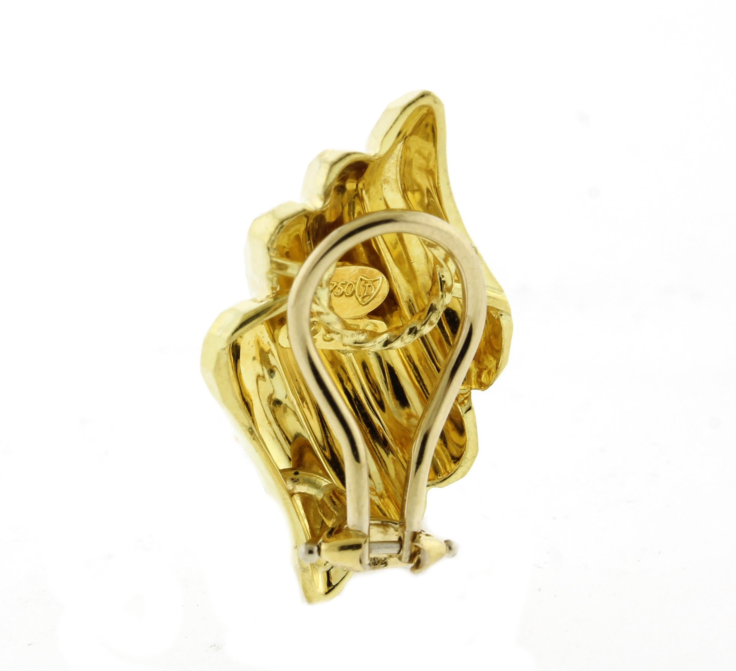 Gli orecchini a clip in oro giallo 18kt martellato di Henry Dunay offrono un look audace ma elegante. Con un peso di 16,6 grammi, offrono una sensazione di solidità pur rimanendo comode da indossare. Ogni orecchino è timbrato con la firma Dunay e