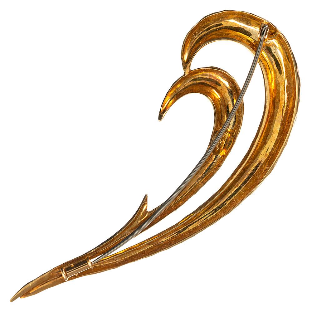 Hammered hooks of 18 karat yellow gold are married side-by-side to create a contemporary design to enhance any lapel. The piece measures 3.5 inches long and 1.5 inches wide and is signed Henry Dunay.