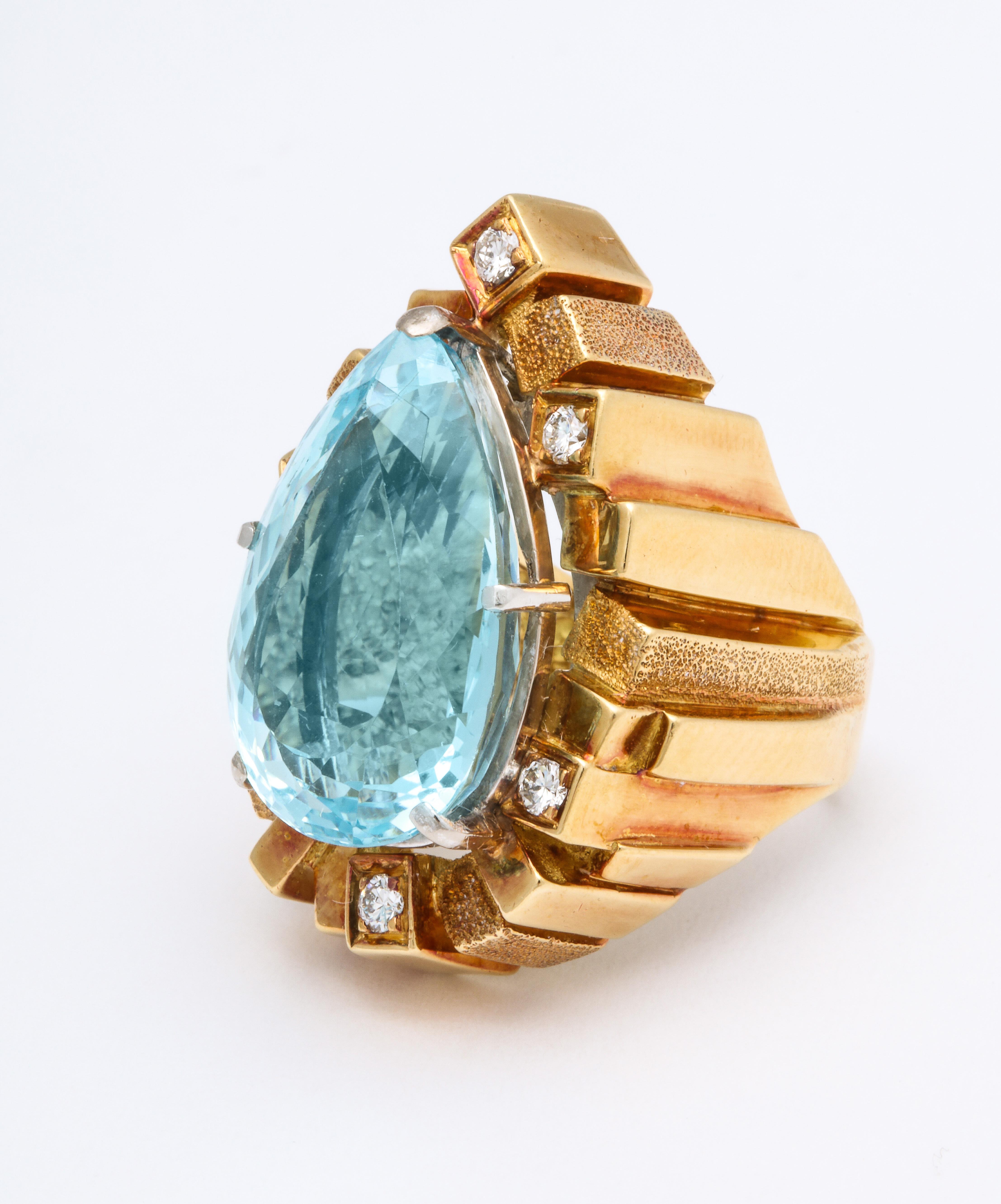 An exceptional design 18k mounting of a large pear shaped faceted Aquamarine with Diamonds set in gold cubes with ridges surrounding the Aquamarine. This rare piece is  hand made and  signed Henry Dunay fr.