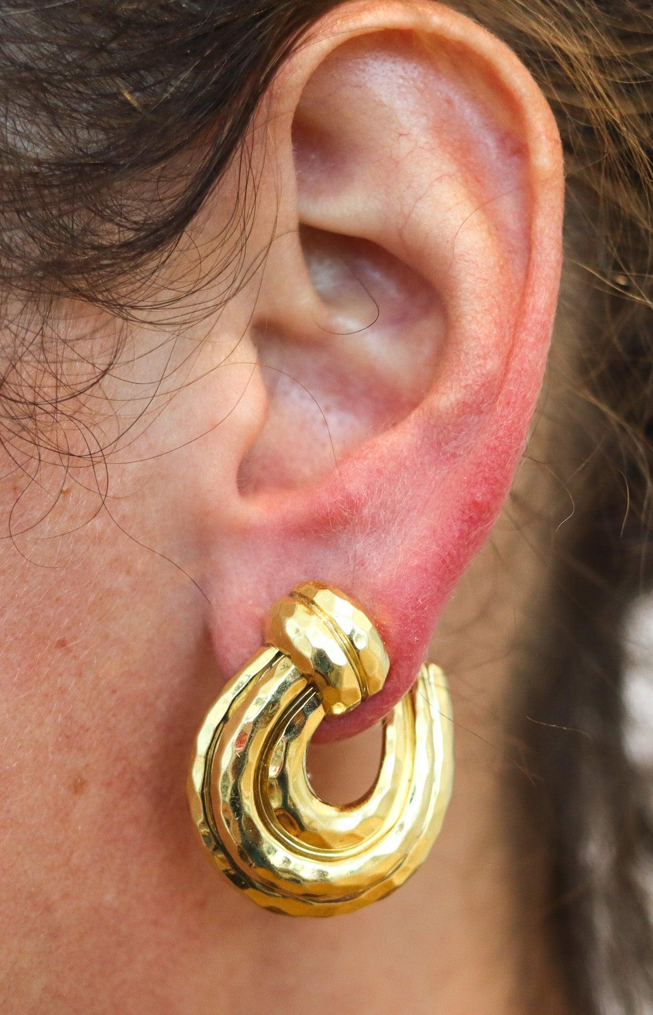 Boucles d'oreilles en forme d'arceau conçues par Henry Dunay.

Il s'agit d'une magnifique paire de boucles d'oreilles, créée à New York dans l'atelier de joaillerie d'Henry Dunay, dans les années 1990. Les boucles d'oreilles ont été réalisées en or
