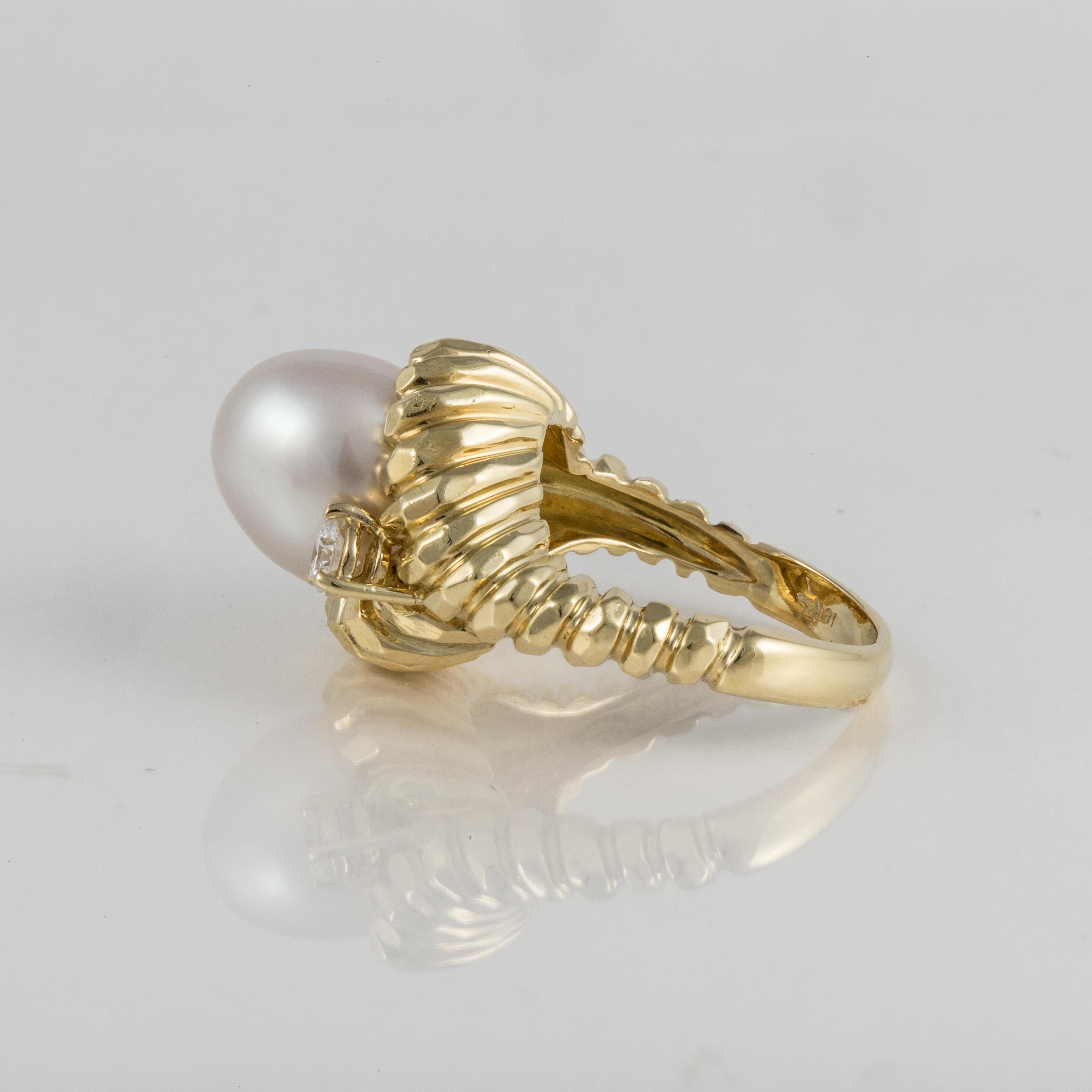 Henry Dunay ring in 18K yellow gold featuring a cultured pearl accented by round diamonds. The cultured pearl measures 10.7 mm by 12 mm.  The two round brilliant-cut diamonds total 0.40 carats; G-H color and VS clarity.  The presentation area