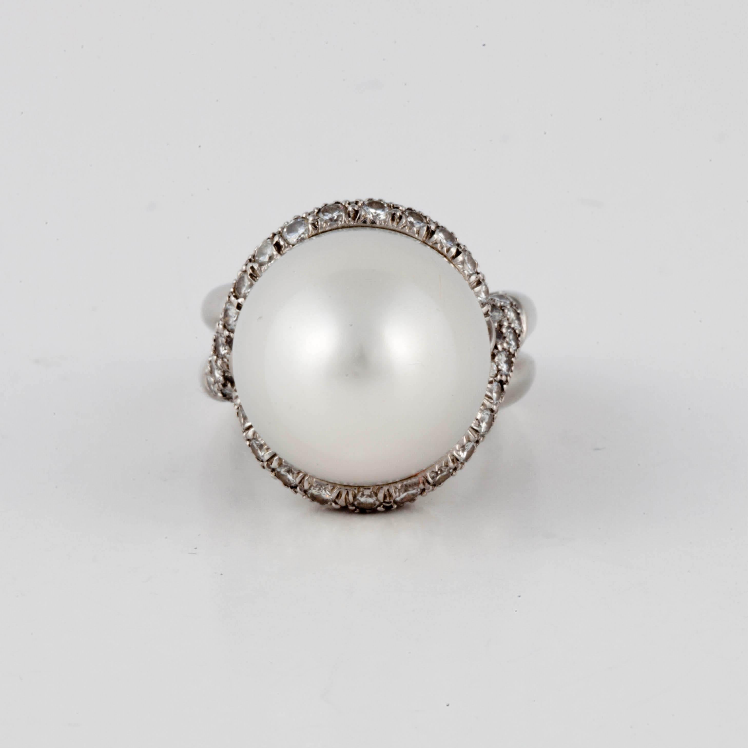 Henry Dunay platinum ring featuring a large baroque pearl surrounded by diamonds.  There are 82 round diamonds surrounding the pearl which total 3.28 carats; G-H color and VS1-2 clarity.  The ring is a size 6 with a butterfly insert.  Measures 3/4