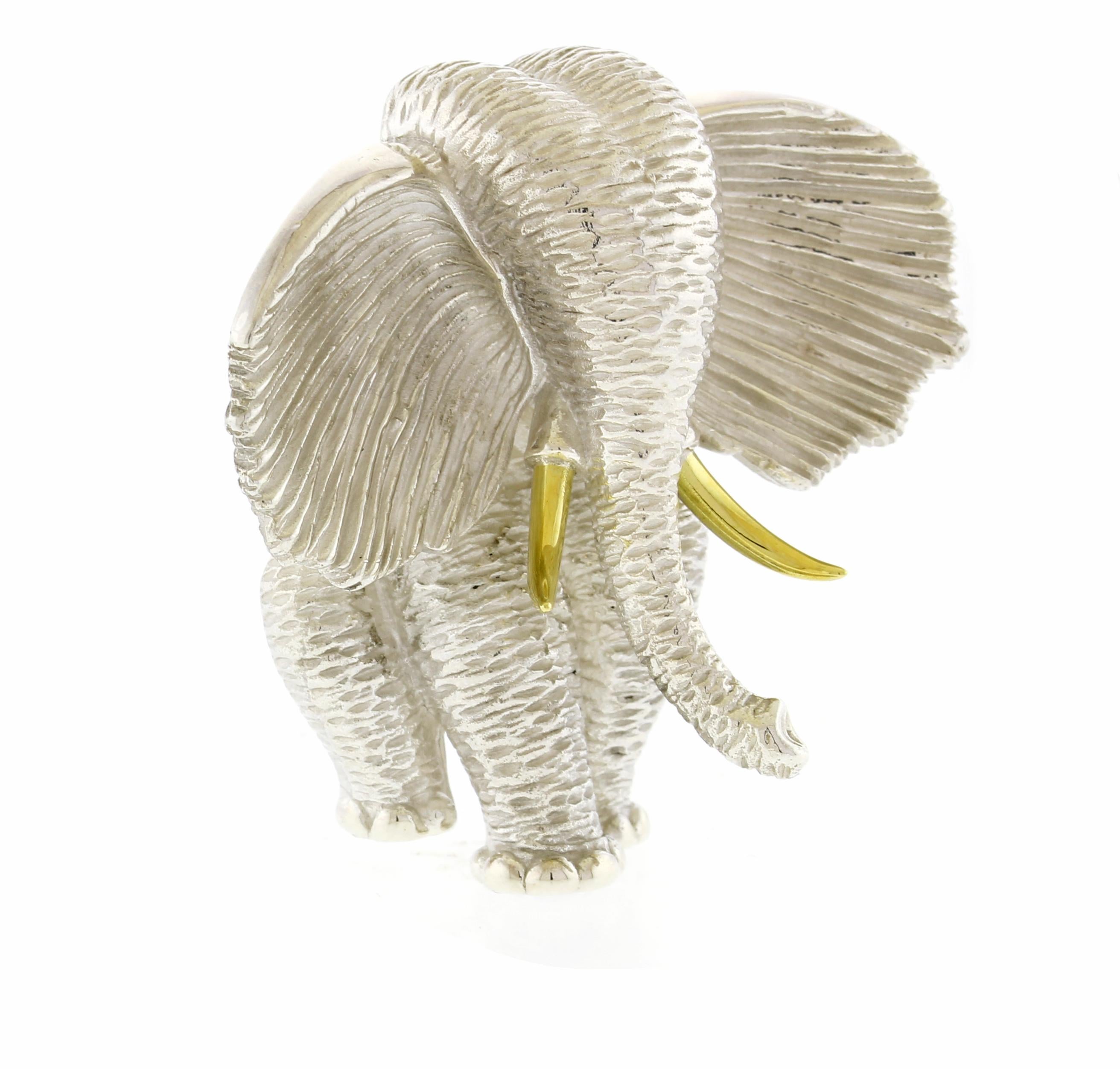 Discover the artistry of Henry Dunay with this captivating African elephant brooch, meticulously sculpted in sterling silver. This exquisite piece stands 1 5/8 inches tall and is adorned with 18 karat gold tusks, adding a touch of opulence to its