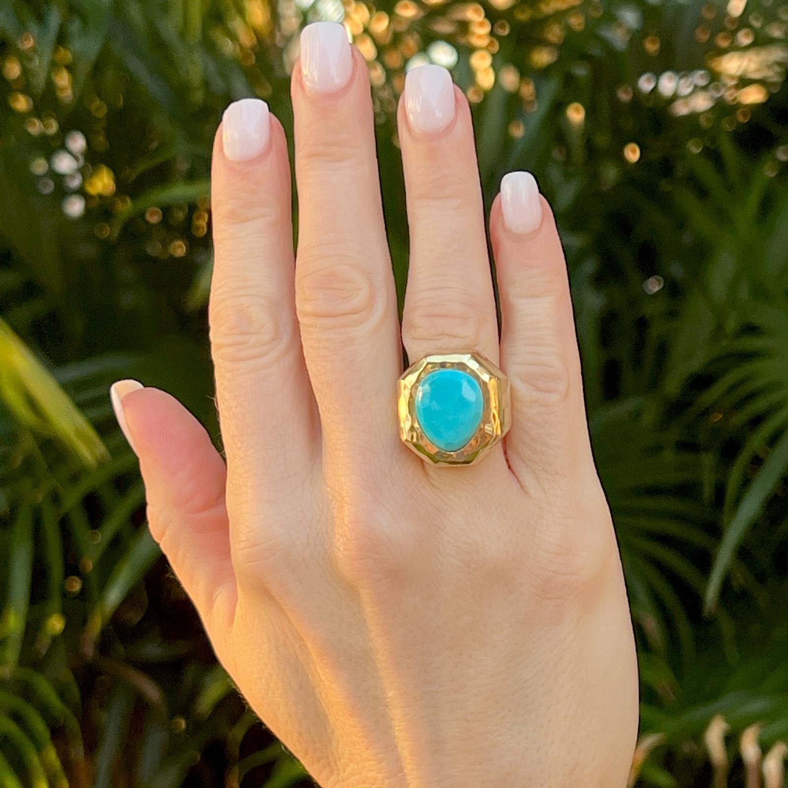 Fabulous turquoise and 18 karat yellow gold ring by American designer Henry Dunay. The bright gold hammered finish ring features a bezel set faceted cabochon turquoise gemstone. The ring measures 20.5 x 22mm and is currently size 5 (can be sized). 