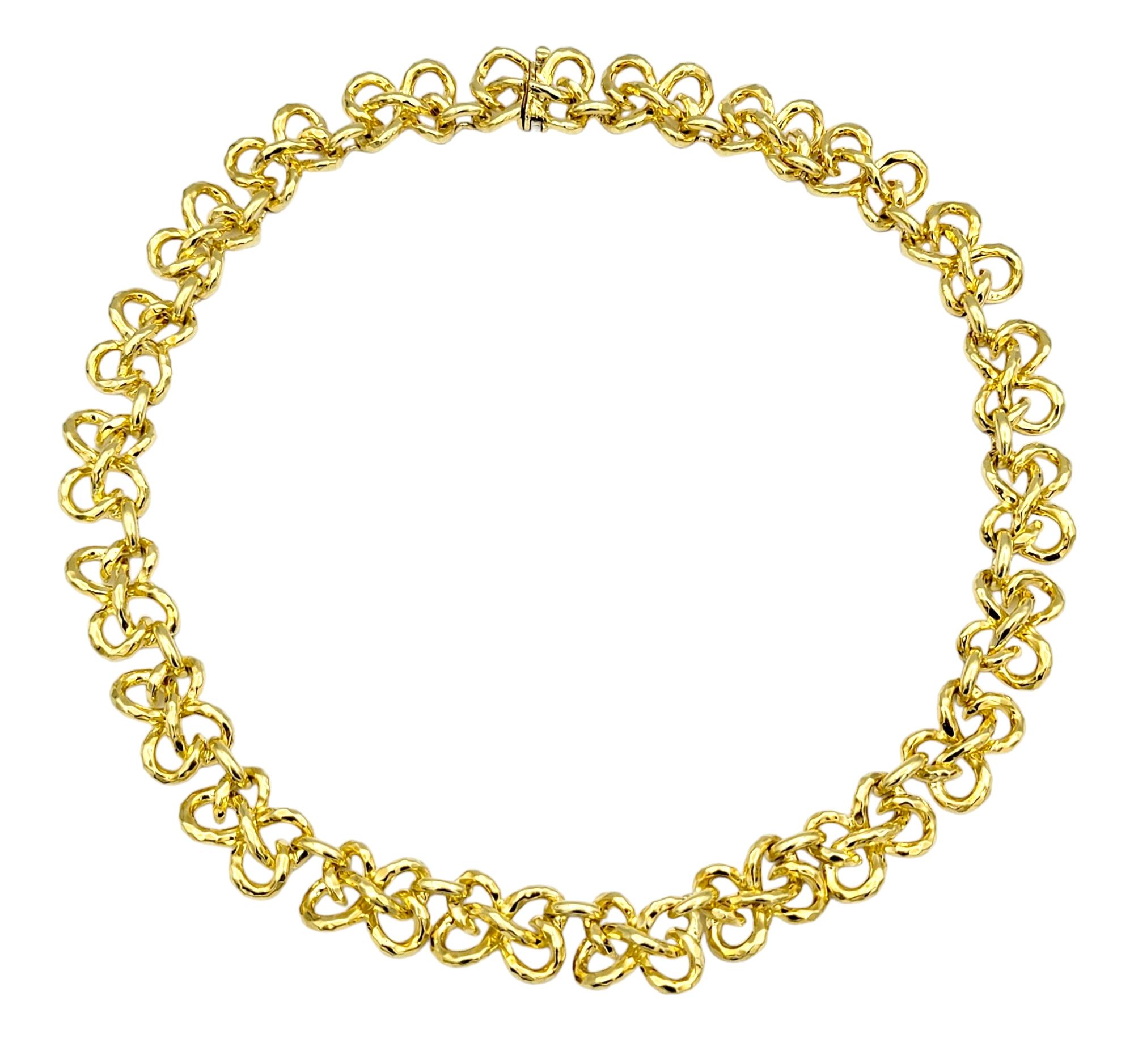 Crafted with exquisite artistry, this Henry Dunay collar necklace showcases a mesmerizing twisted design, reminiscent of delicately intertwined ribbons. Meticulously fashioned from radiant 18 karat yellow gold, each twist of the gold ribbon links