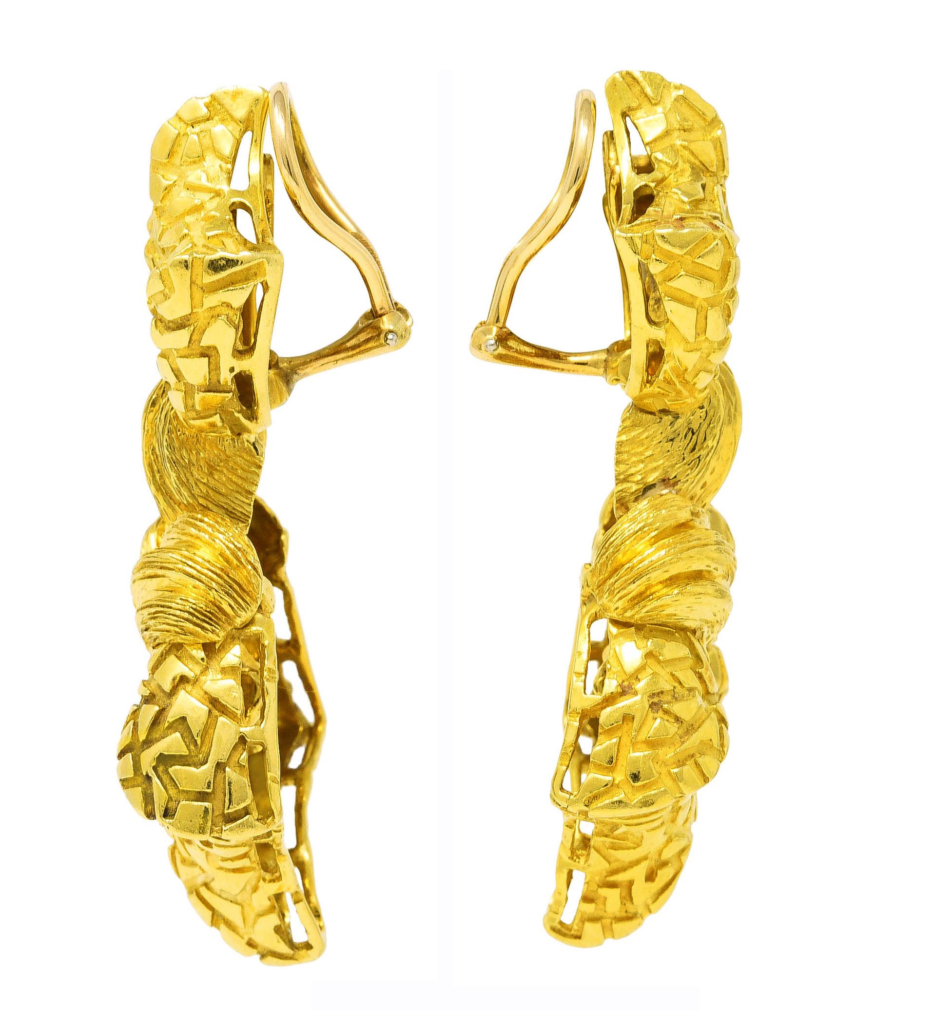 Ear-clip earrings are designed as two faceted geometric forms with cracked motif throughout

Featuring sweeping brushed gold motif connecting both forms

Completed by hinged omega backs

Stamped 18k for 18 karat gold

With maker's mark for Henry
