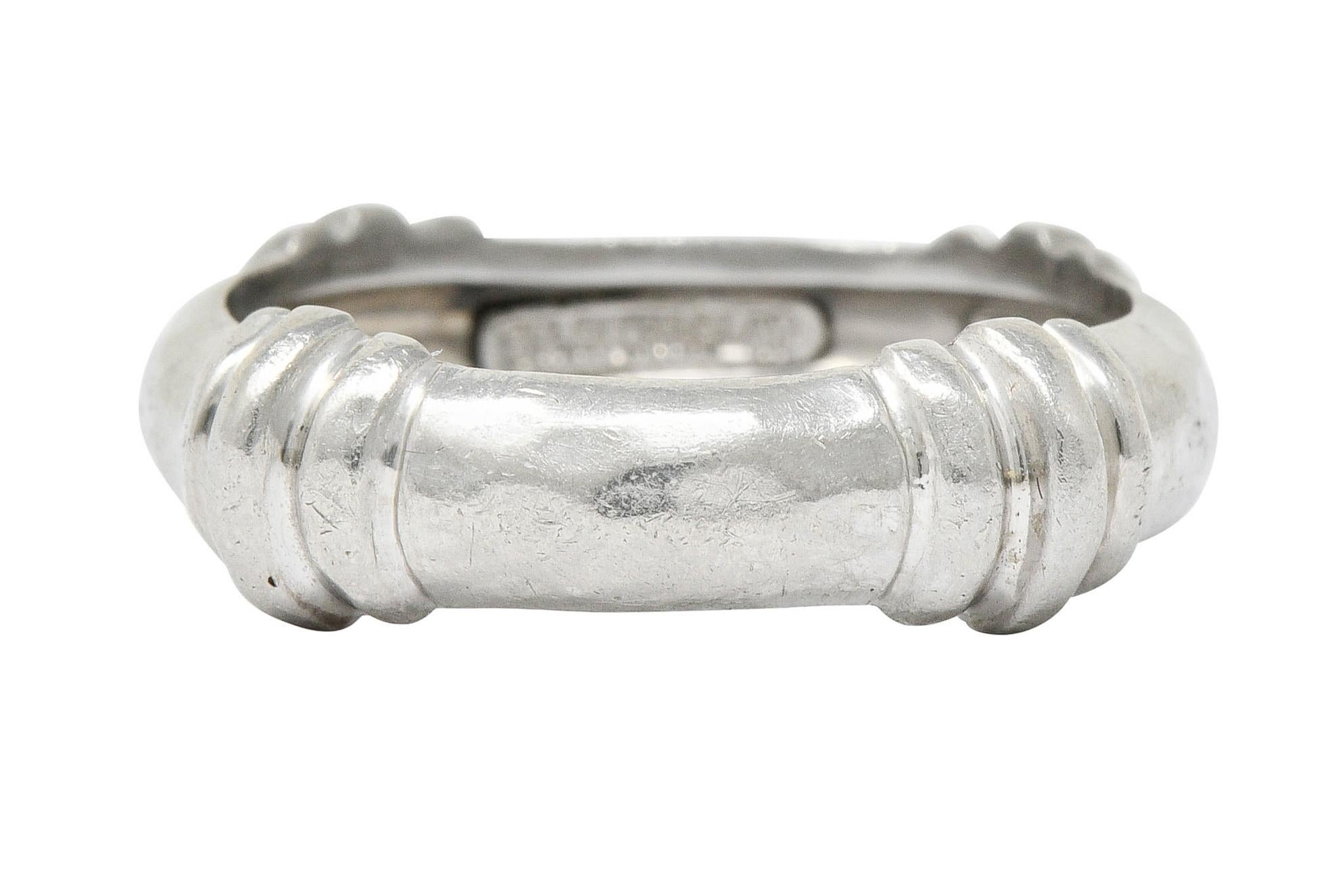 Band ring features four deeply ribbed stations

And exhibits a hammered finish

Numbered and signed Dunay for Henry Dunay

Stamped for platinum

Circa: 1990s

Ring Size: 7 3/4 & not sizable

Measures: 6.4 mm wide and sits 3.0 mm high

Total weight: