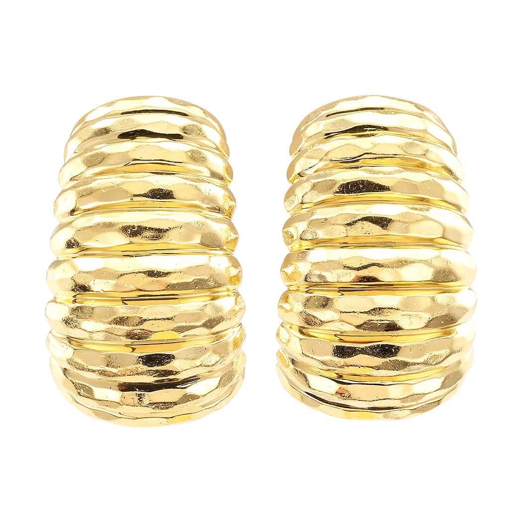 Henry Dunay yellow gold clip on hoop earrings circa 1990. 

DETAILS:
METAL: 18-karat yellow gold decorated by hammered texture and horizontally fluting.

MEASUREMENTS: approximately 1-1/8” (2.9 cm) long and 11/16” (1.7 cm) wide overall, 31.4