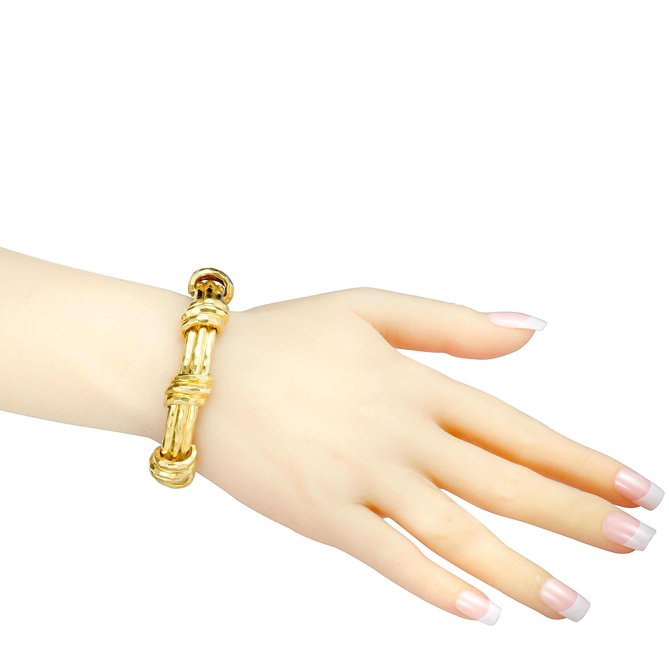 Presented in alluringly radiant 18K yellow gold and boasting exquisite hammered finish, this compelling bracelet from Henry Dunay offers an incredibly fashionable look with a distinct luxe feel about it. This superb statement piece weighs 76.3 grams.