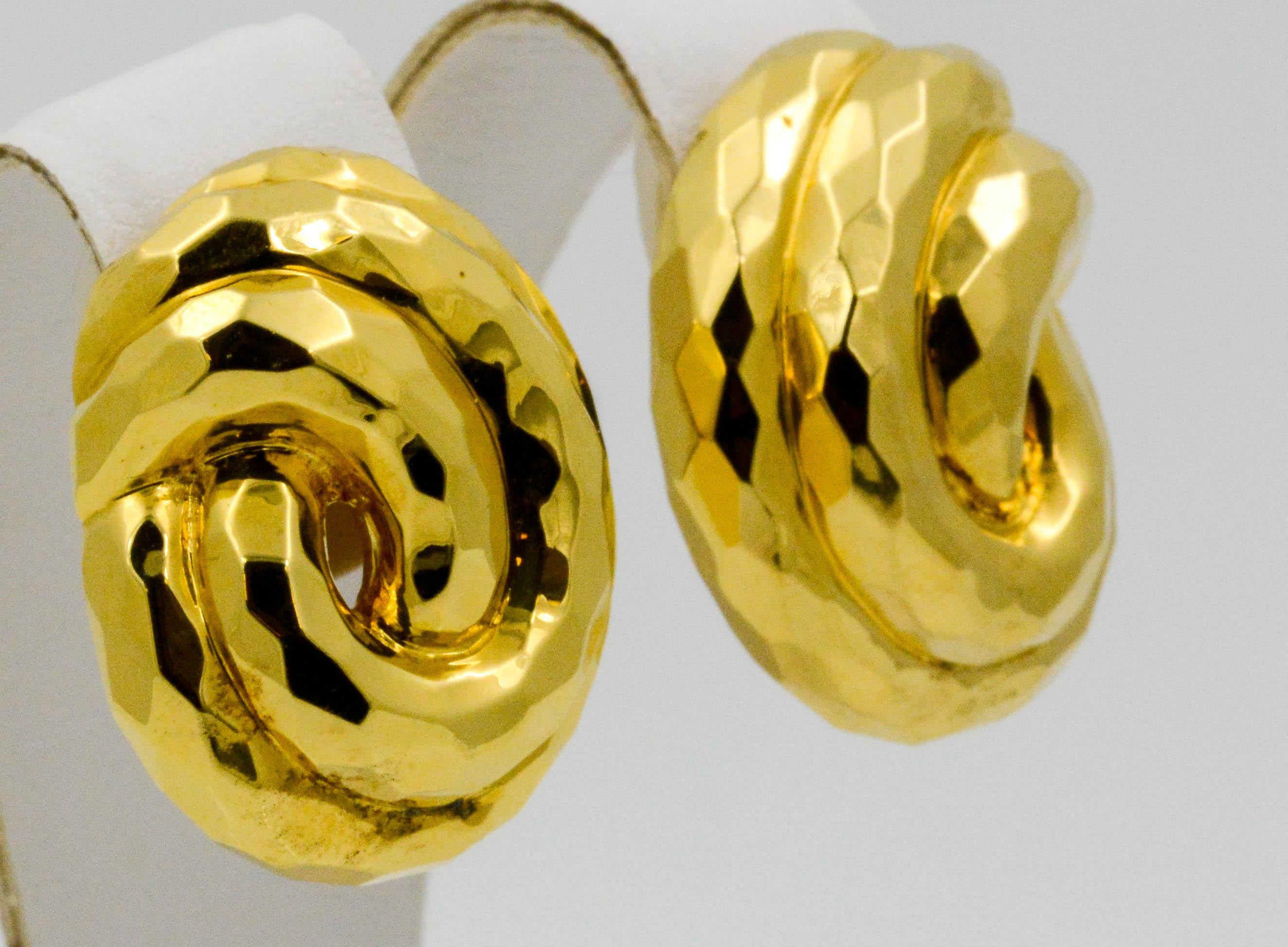 These Henry Dunay 18k yellow gold clip earrings create a polish and classic look. The earrings have a swirl pattern that consists of two intertwining loops to give a classic knotted design.  