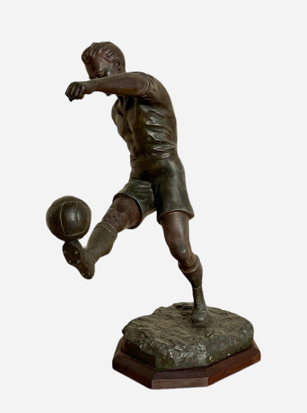 Spelter sculpture with green patina representing a young footballer. Signed on the terrace 