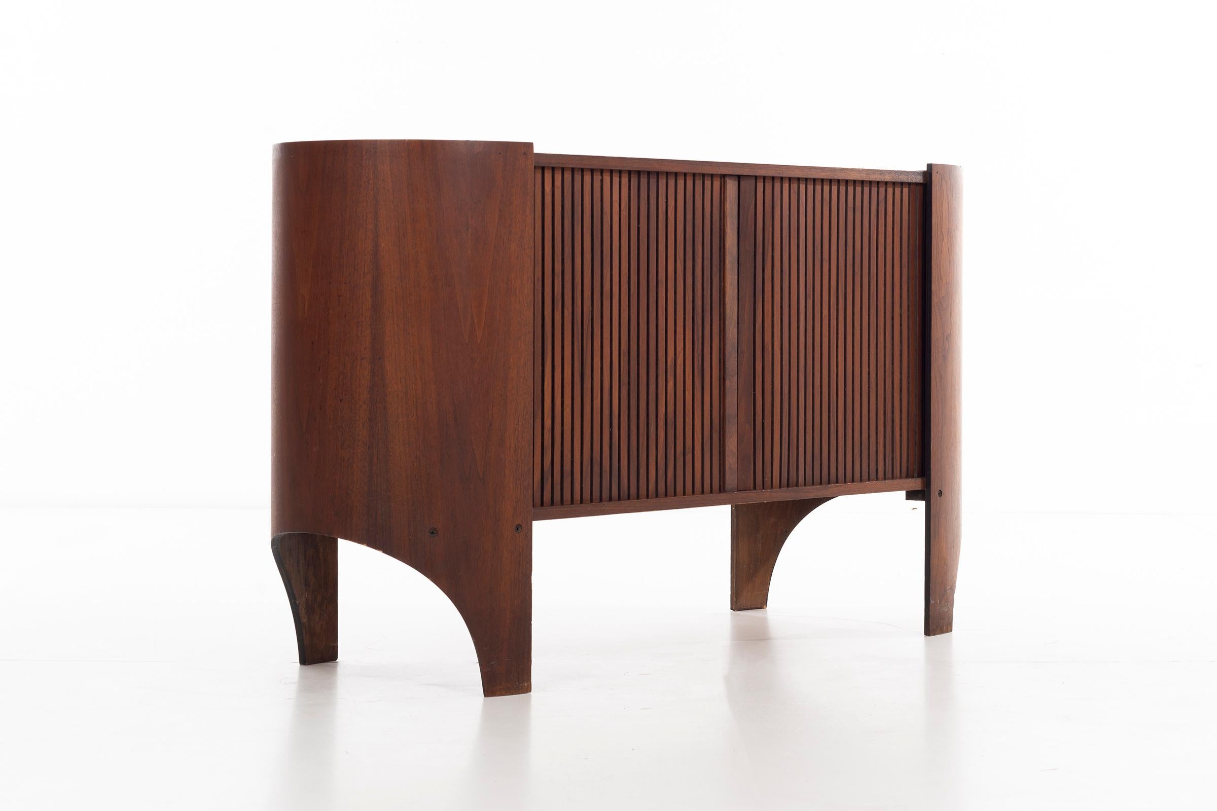 Glass for the Island Series, tambour door Credenza in oiled walnut, case conceals vertical divided interior, half shelf with pull-out drawer with divided organized partitions, opposing side partial shelf. 
Scale good to be used as a console.

  