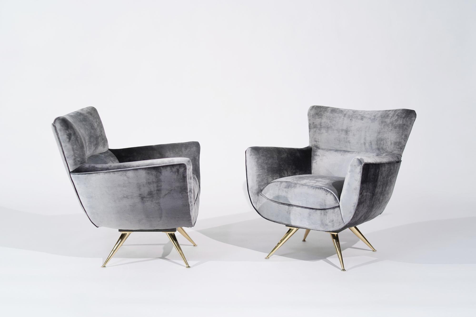 A meticulously restored pair of Henry Glass Swivel Chairs, a captivating blend of 1950s charm and contemporary elegance. Upholstered in distressed silver velvet, these chairs feature newly brass-plated angled legs, adding a touch of glamour and