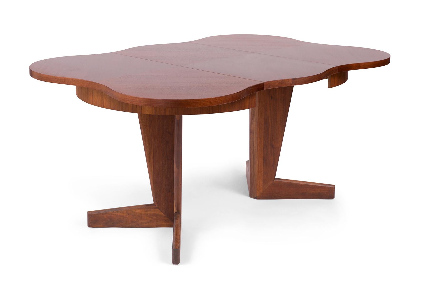 This 1960s walnut dining table by Henry Glass boasts extraordinary sculptural form. The table can seat four and has two extra leaves to extend the length for accommodating six to eight. The table measures 42