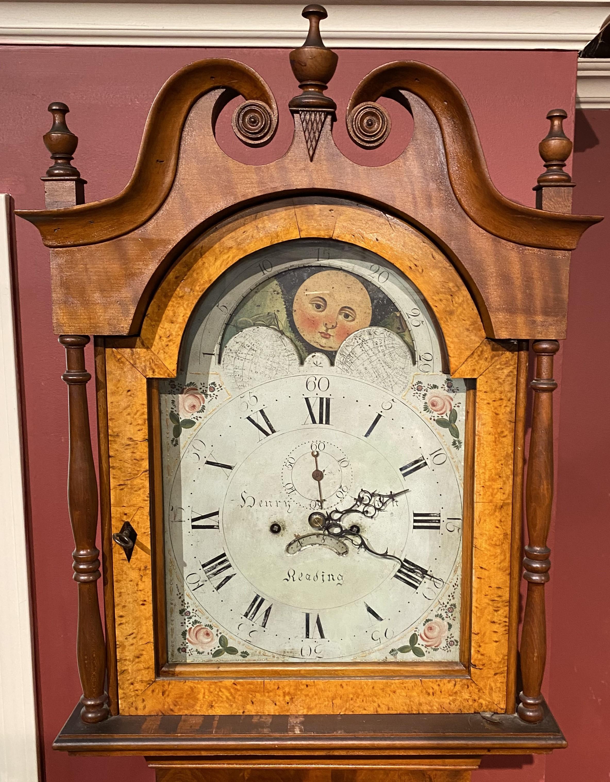 A fine example of a cherry tall case clock by Henry Hahn of Reading, PA, active clockmaker from 1790-1820, with broken pediment carved arched bonnet with scroll rosettes, urn finials, and birdseye maple tombstone door, flanked by full turned corner