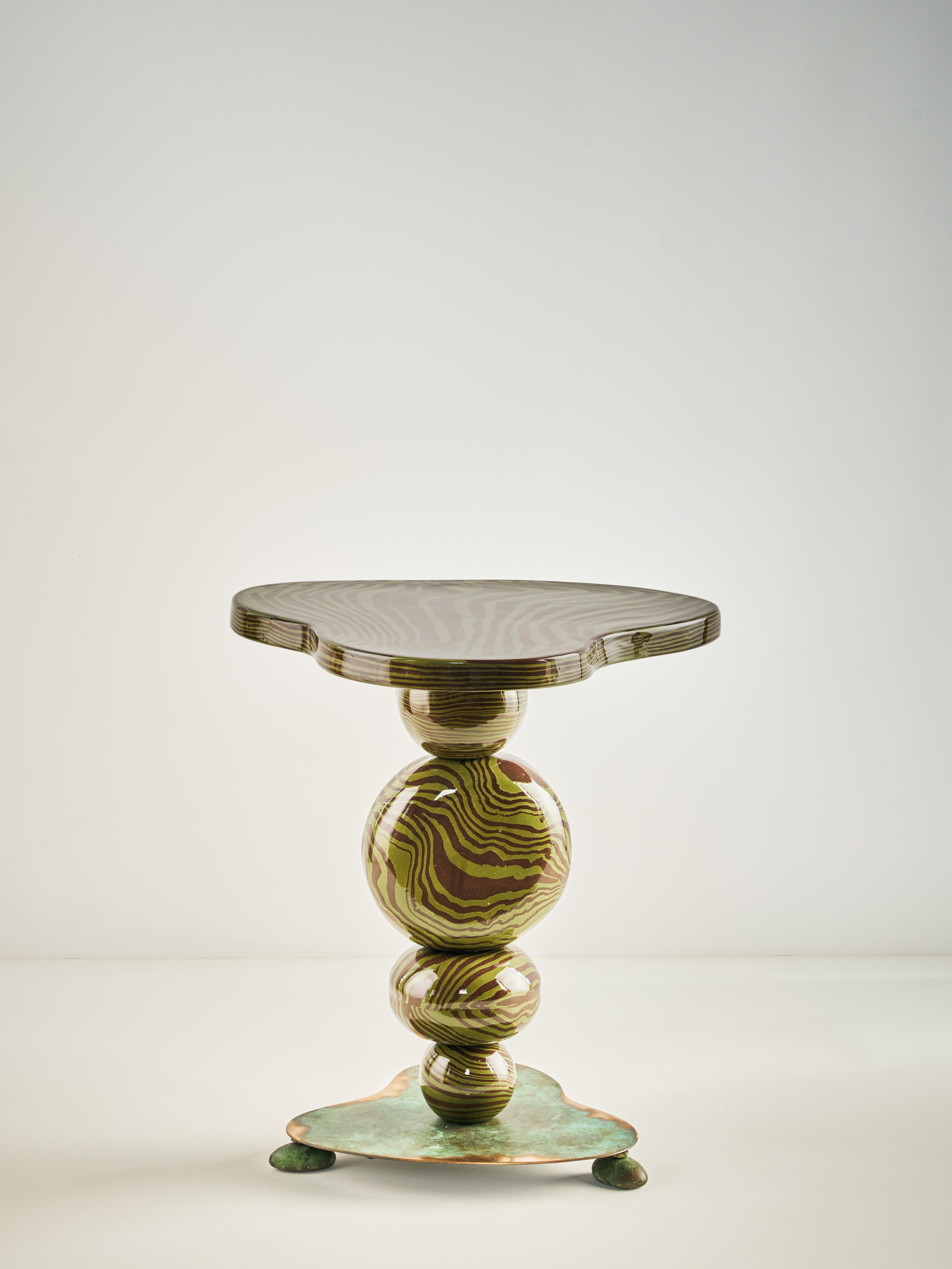 La table d'appoint Alto rehausse votre espace, aussi petit soit-il. Fabriqué à la main selon les techniques traditionnelles de construction de dalles Nerikomi. Des sphères en céramique sont enfilées sur une colonne centrale, reposant sous une