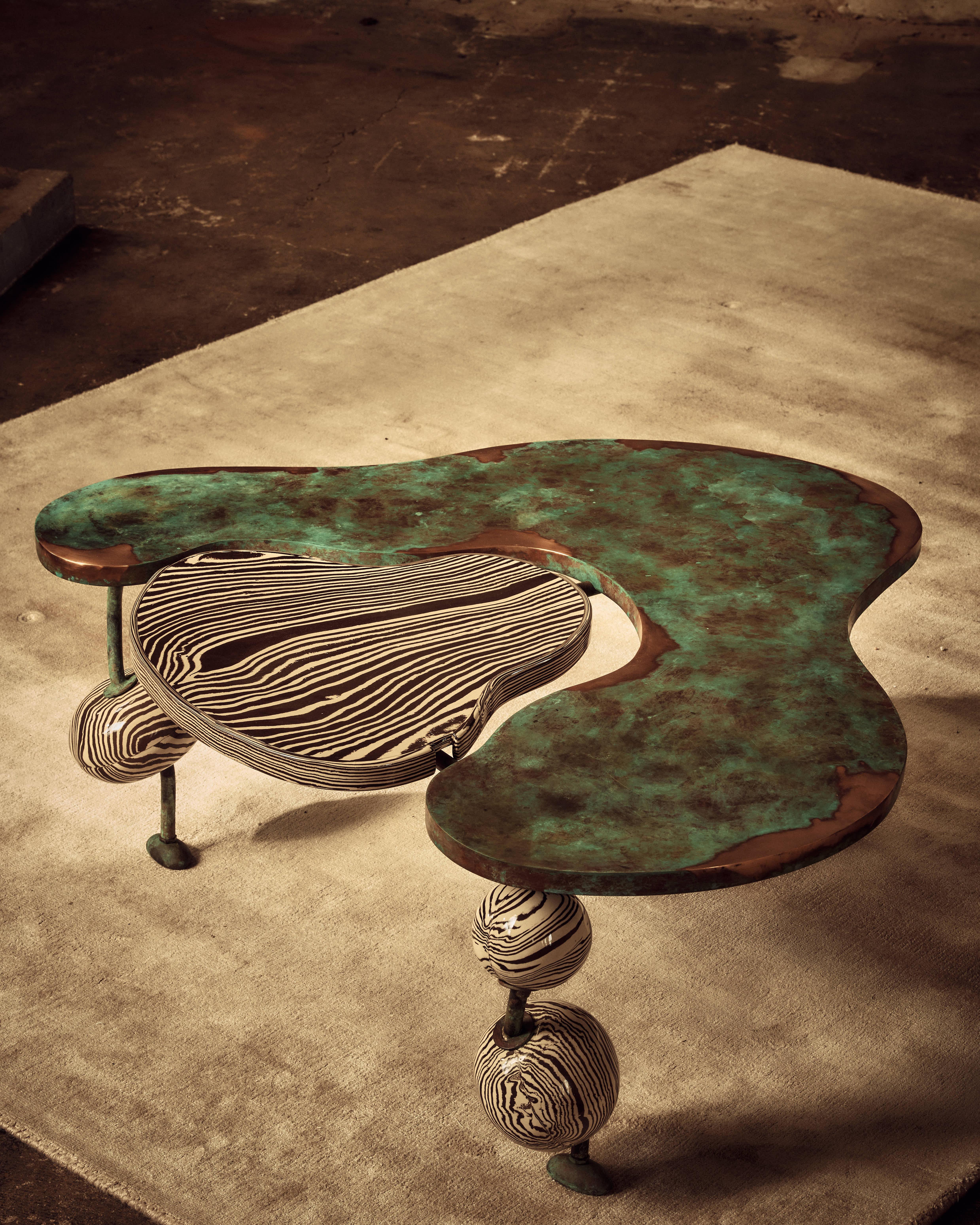 La table basse Nimbo est conçue pour construire votre pièce autour. Tessellation de formes organiques dans un mélange de bronze et de céramique qui se complètent et se contredisent. Le plateau de la table en bronze est poli pour retrouver sa