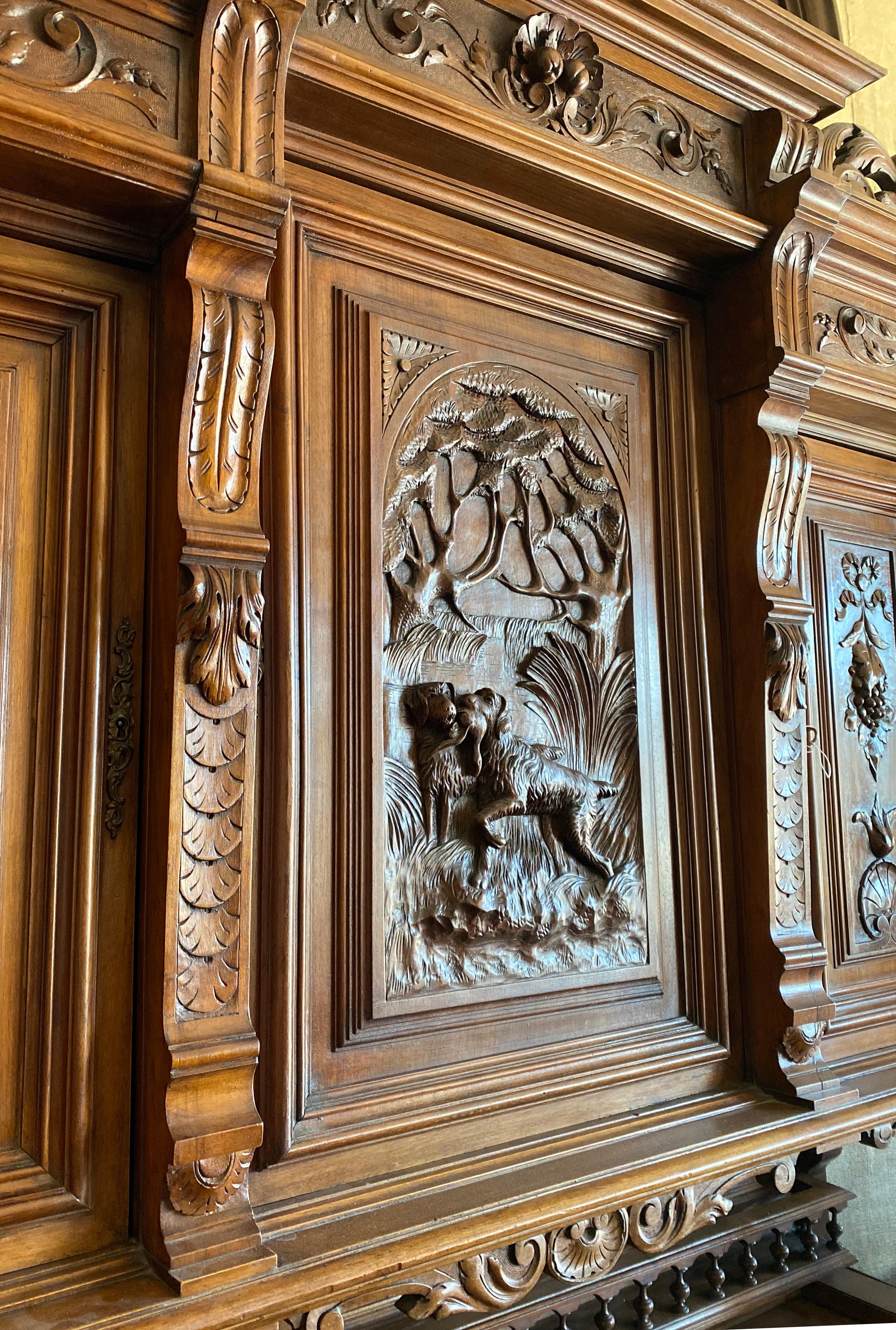 This intricately carved, beautiful wooden cabinet originates from France circa 1890. The center cabinet features a scene depicting a labrador carrying a catch of the day from hunting in the country.

Measurements: 68