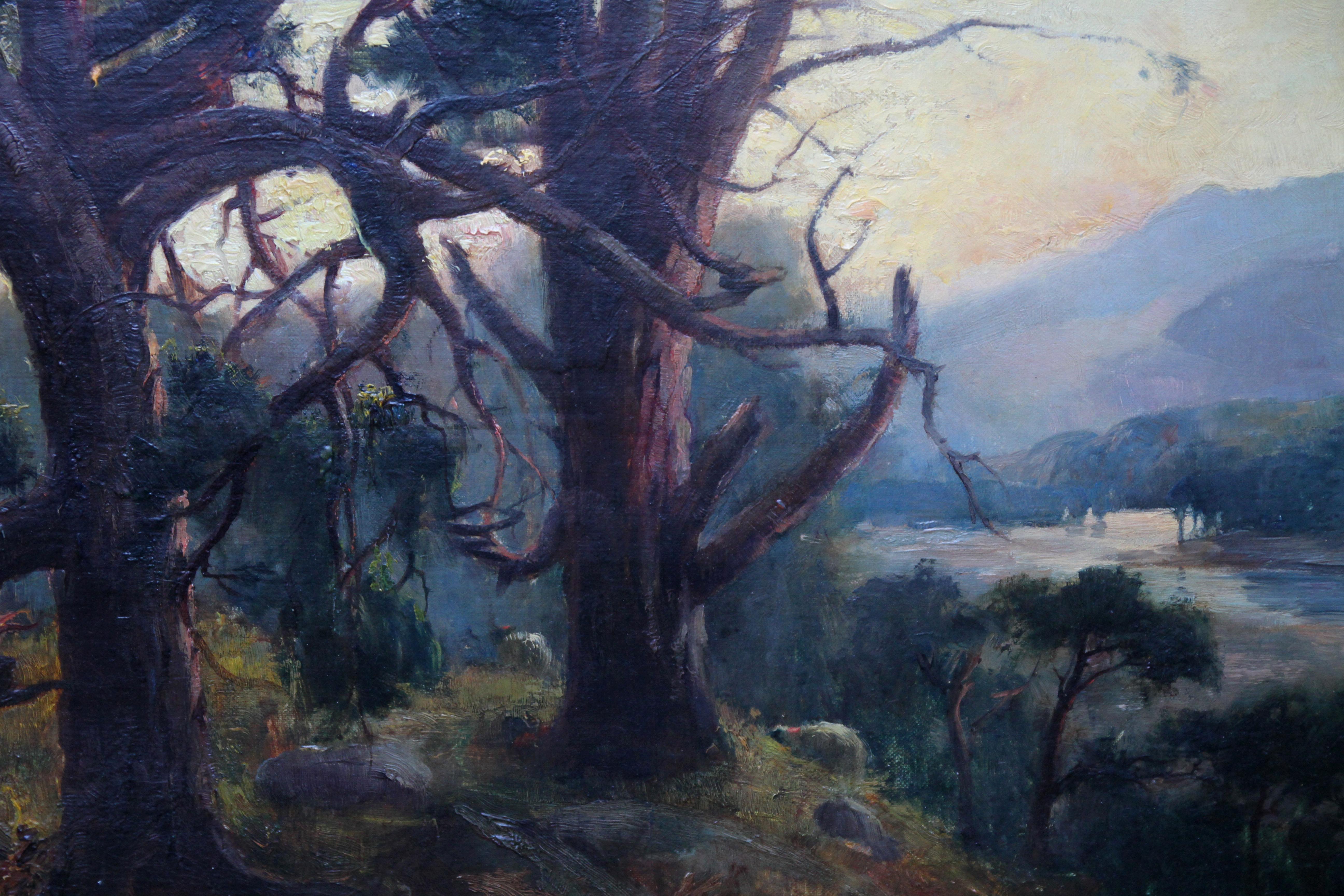 This charming atmospheric oil painting is by Scottish artist Henry Jobson Bell and was painted in 1904. The work depicts a sunset view from pine trees looking down onto a river and more hills in the background. The painting has a very soft