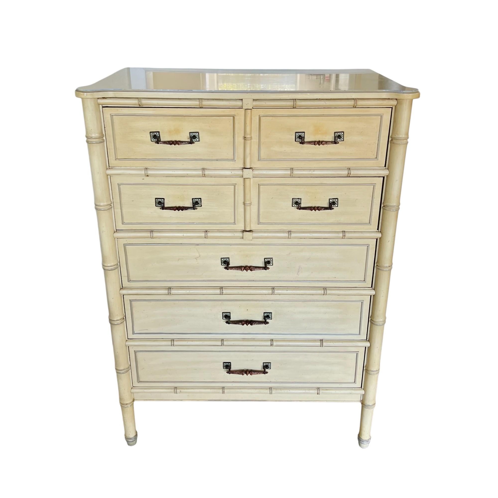 A vintage Palm Beach regency faux bamboo highboy dresser by Henry Link from the Bali Hai collection of the 1970's. It features five framed drawers with patinated bronze handles and retains its original finish in cream tones with taupe