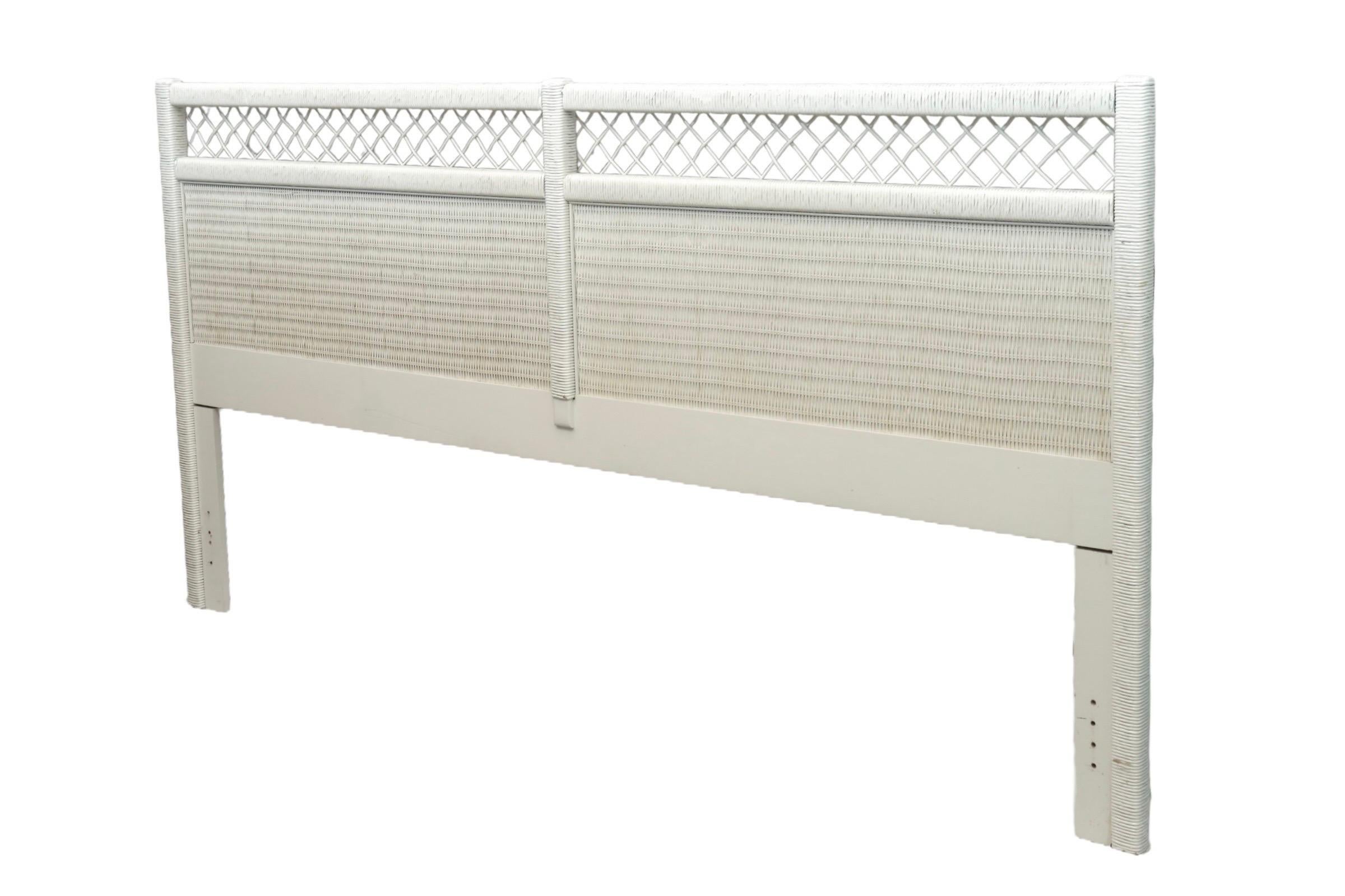 A king size white wicker headboard by Henry Link. With clean lines throughout, the rattan wrapped wooden frame supports two wicker panels, topped with an open weave crest rail. Dated “Nov 20, 1986” in the back.

