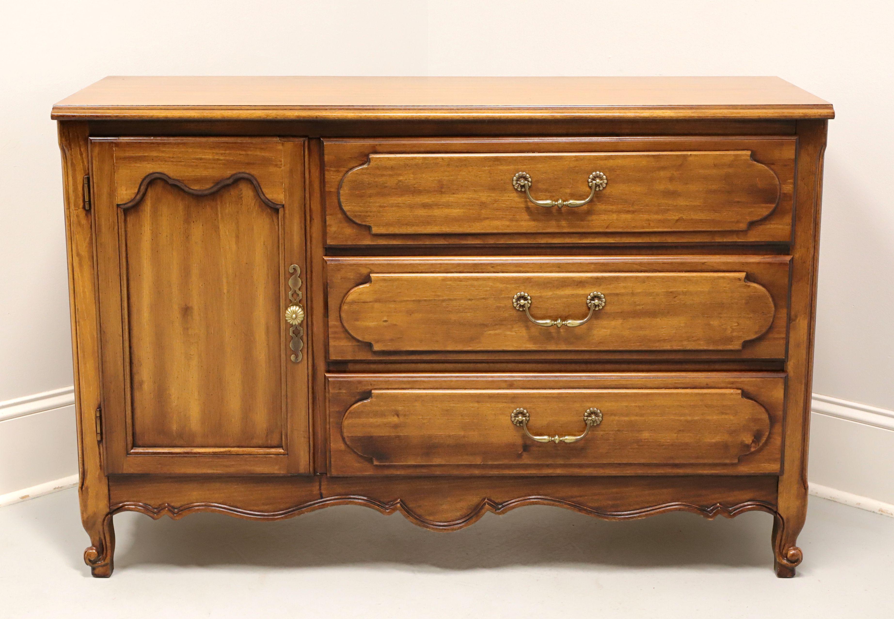 A French Country Louis XV style double dresser by Henry Link, part of Lexington Furniture, from their Margaux Collection. Cherry wood with brass hardware, bevel edge to top, recessed door front, raised drawer fronts, carved apron, and scroll front