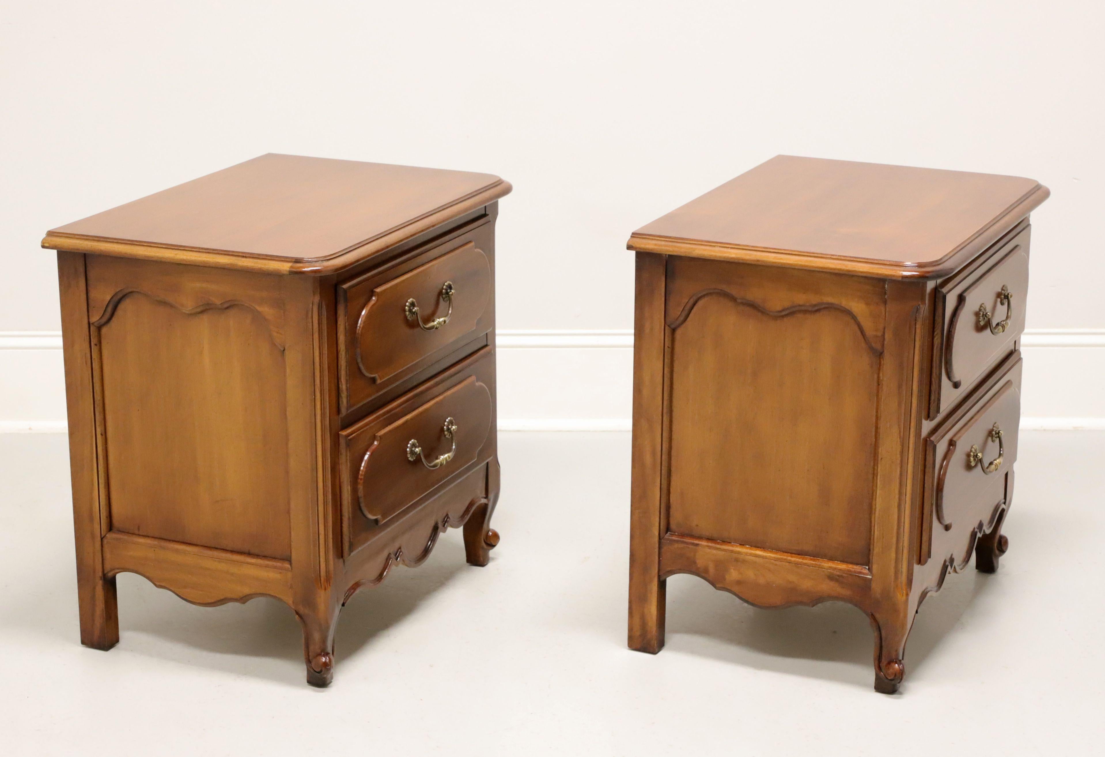 A pair of French Country Louis XV style nightstands by Henry Link, part of Lexington Furniture, from their Margaux Collection. Cherry wood with brass hardware, bevel edge to top, raised drawer fronts, carved apron, and scroll front feet. Features