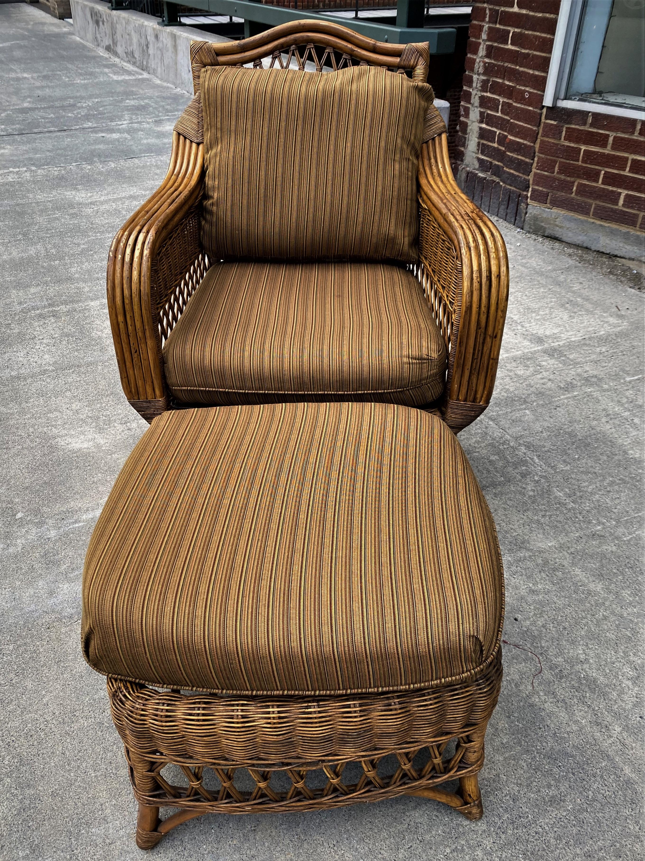 This is a great looking Henry Link Rattan armchair with matching ottoman that has very neutral brown and dark color striped upholstery which has some minor pulls and discoloration but is very useable and will blend with florals or other patterns.