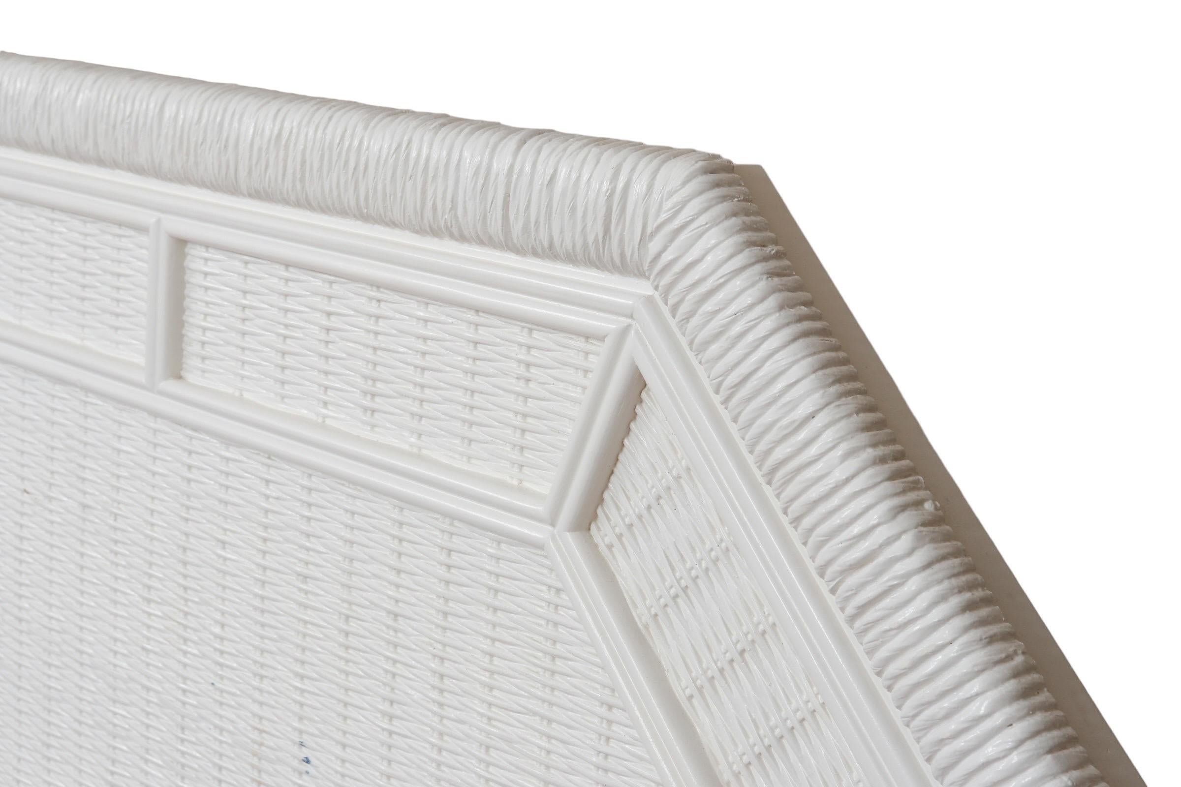 A pair of twin-size white wicker headboards by Henry Link. Clean lines throughout, with a border of beveled wooden panels over rattan wrapped wooden frames. Painted all in white, marked in the back “Made in the USA”. Dimensions per headboard.