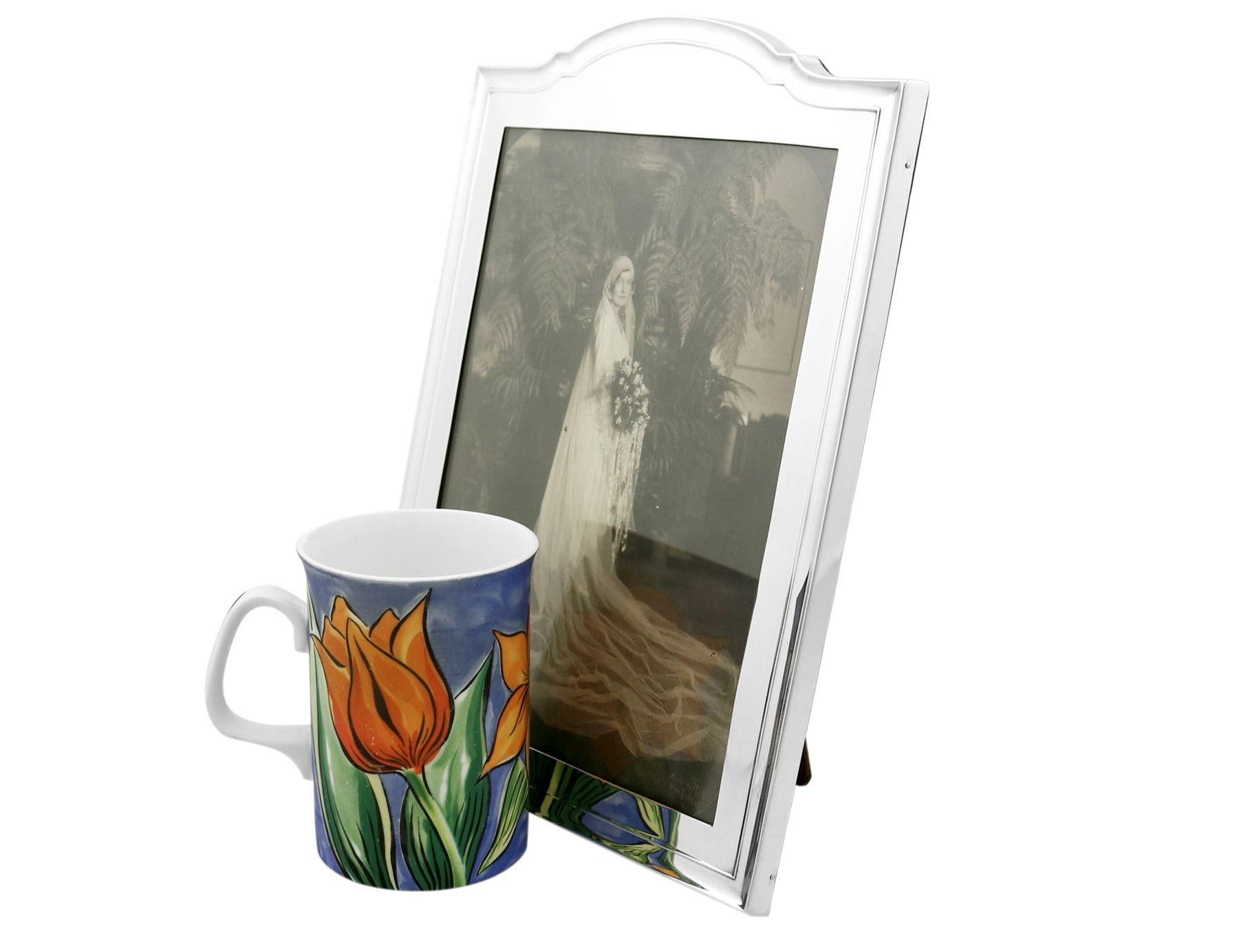 An exceptional, fine and impressive antique English sterling silver photograph frame; an addition to our ornamental silverware collection.

This exceptional antique sterling silver photograph frame has a rounded rectangular form with an incurved,