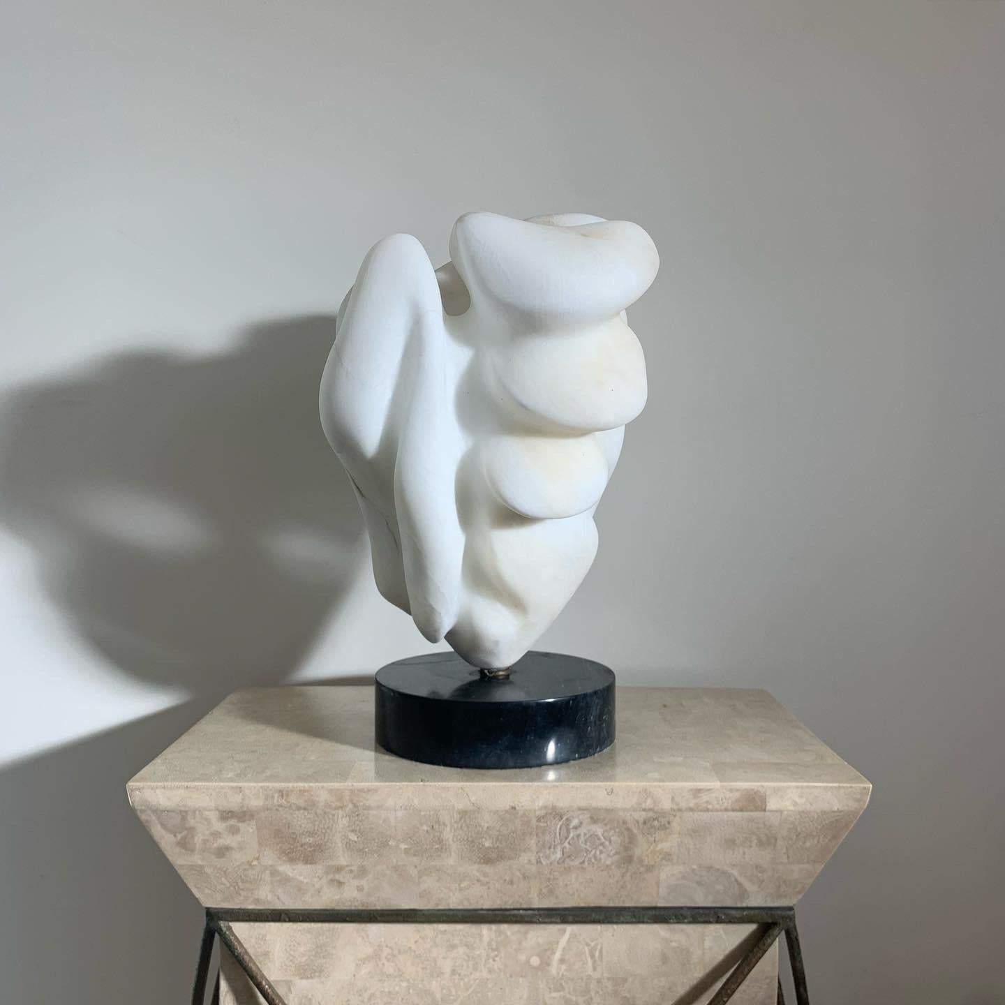 A fine art marble sculpture, 1960s. Hand-carved. Mounted upon a black marble plinth. Minor weathering but overall fabulous condition. Very heavy - 55 lbs. Pick up in LA or delivery options available. 
Measures: 9.5” W X 17.25” H.