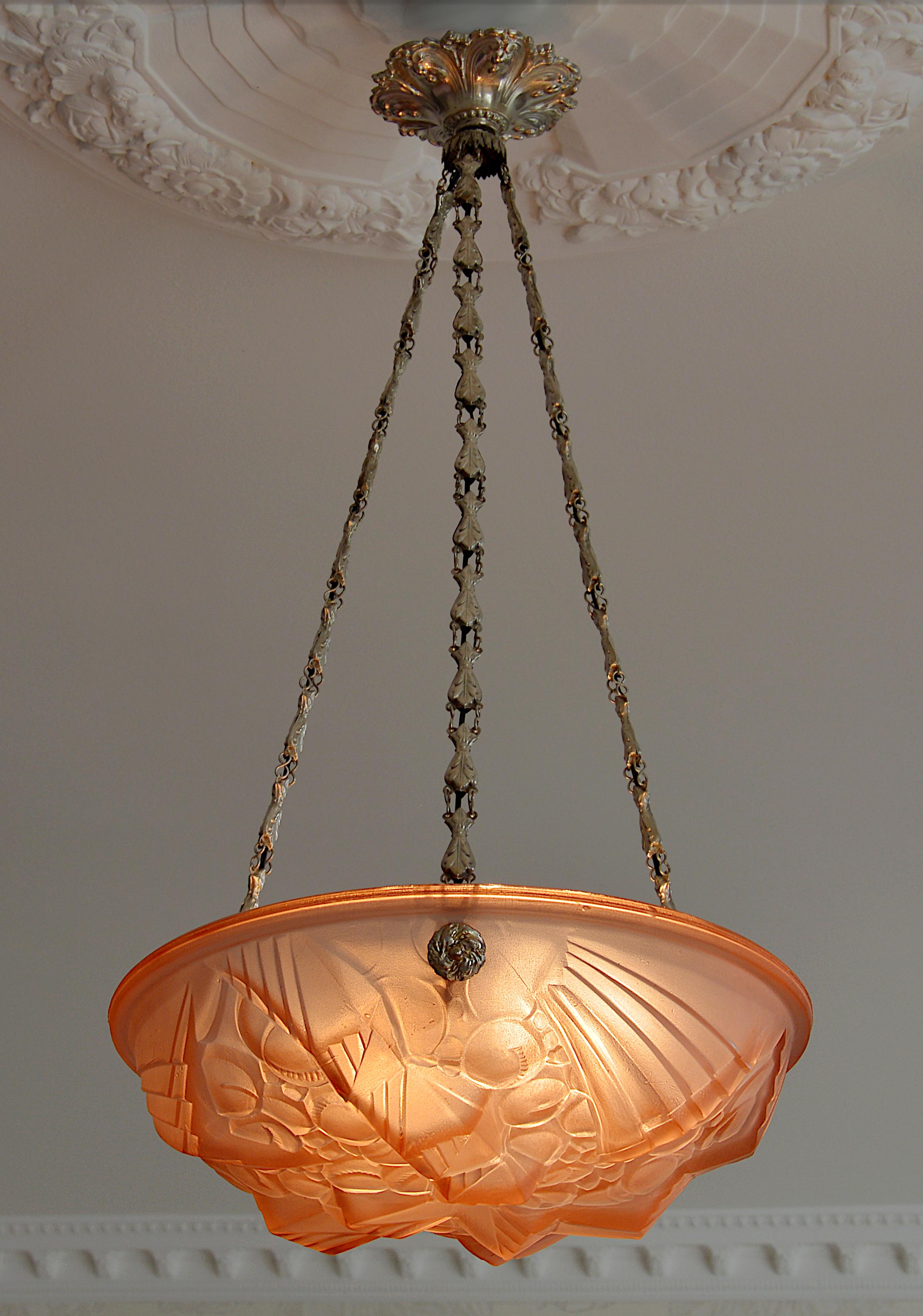Superb French Art Deco pendant chandelier by Mouynet (Paris), France, late 1920s. Pink frosted glass shade with a stylized Art Deco pattern. Silver plated stamped brass fixture. Measures: Height 27