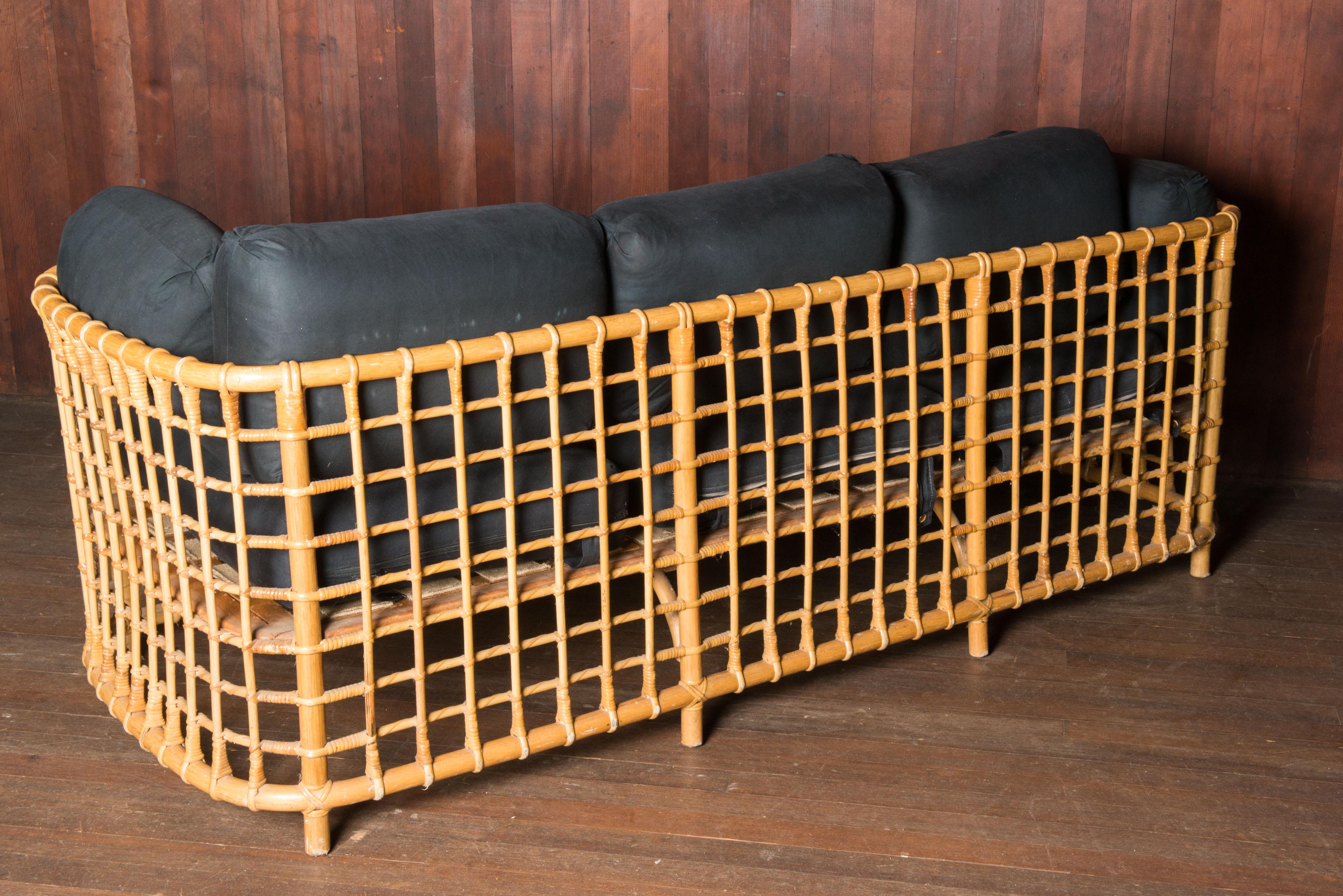 An exquisite and rare rattan sofa by accomplished Henry Olko for his Willow and Reed company, circa 1975. This unique sofa is from the Olko's Square series.
Substantial and sturdy rattan and hardwood construction with precision cane detail. A very