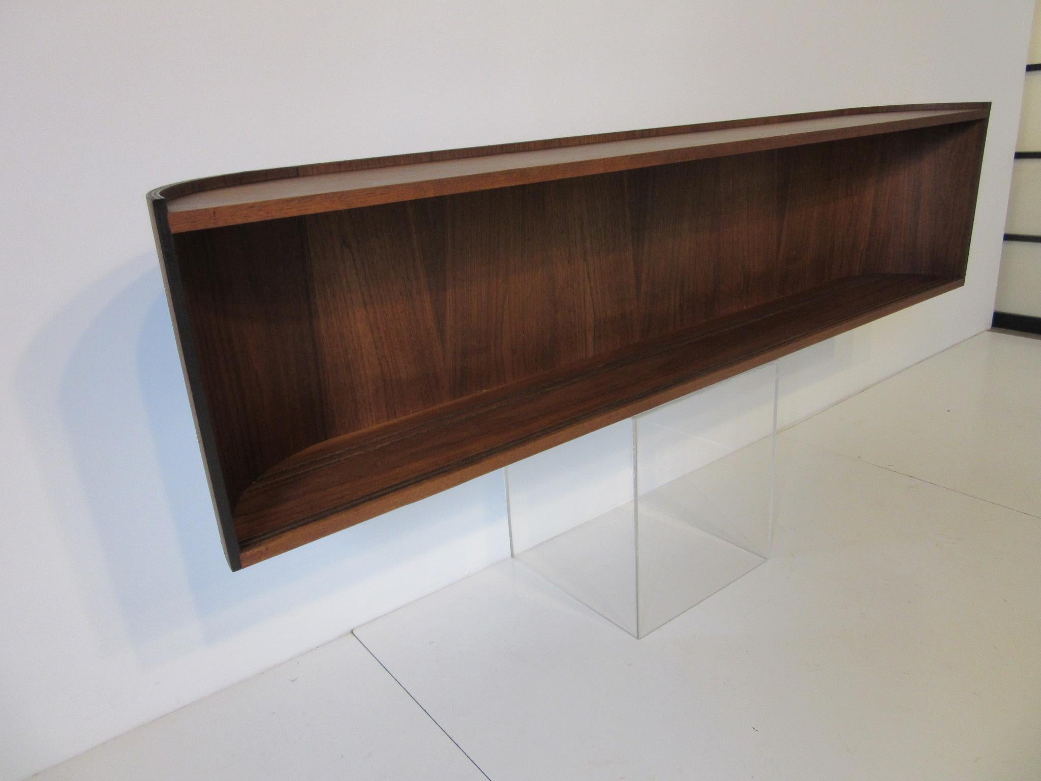 A hanging cabinet with bent walnut curved outer edges and box with two sliding glass doors and wooden cleat to the backside for easy mounting. A simple and yet stylish form that would highlight any interior space.