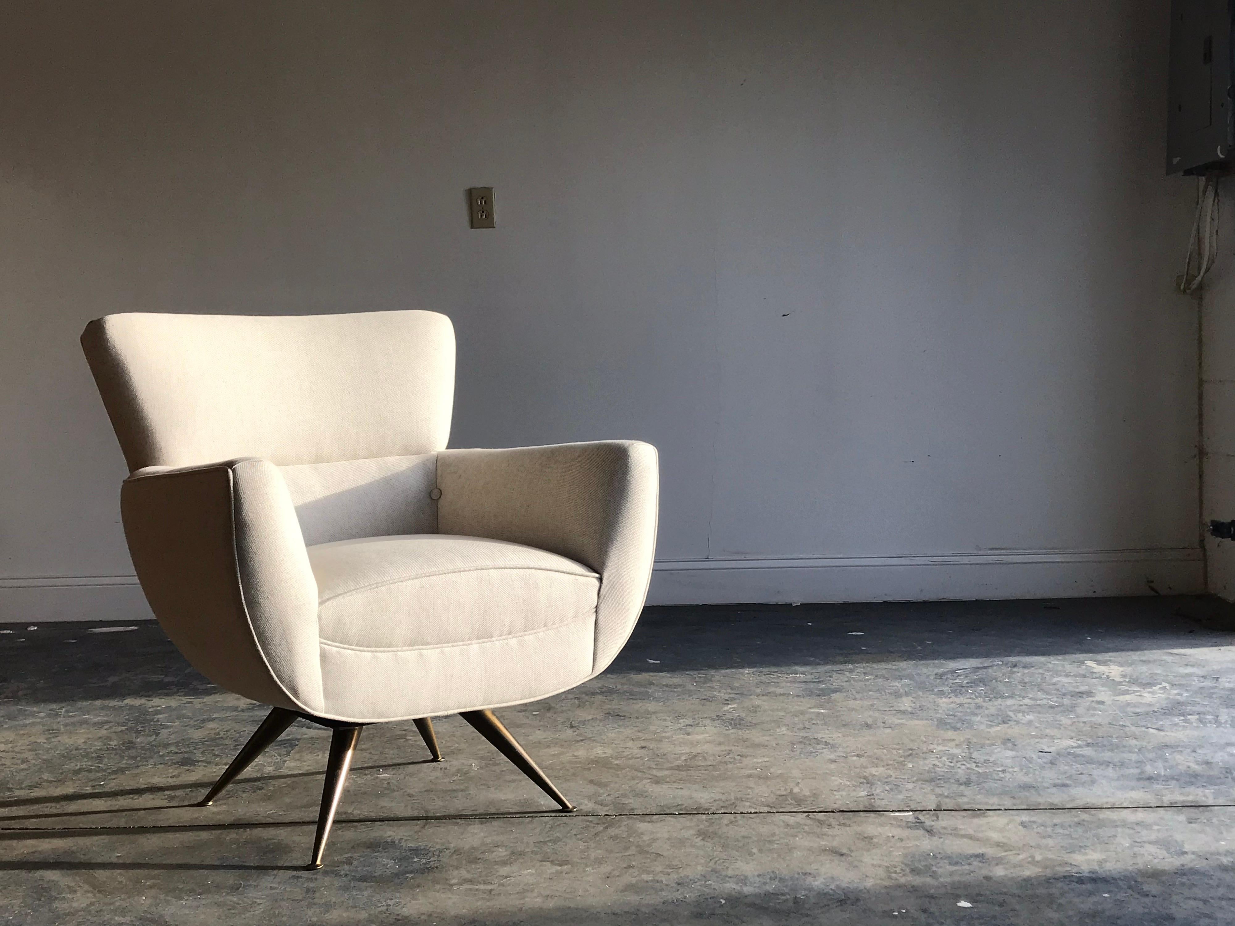 Rare swiveling lounge chair by Henry P. Glass. Reupholstered in a neutral speckled oatmeal fabric. Brass splayed legs in original condition with nice patina.