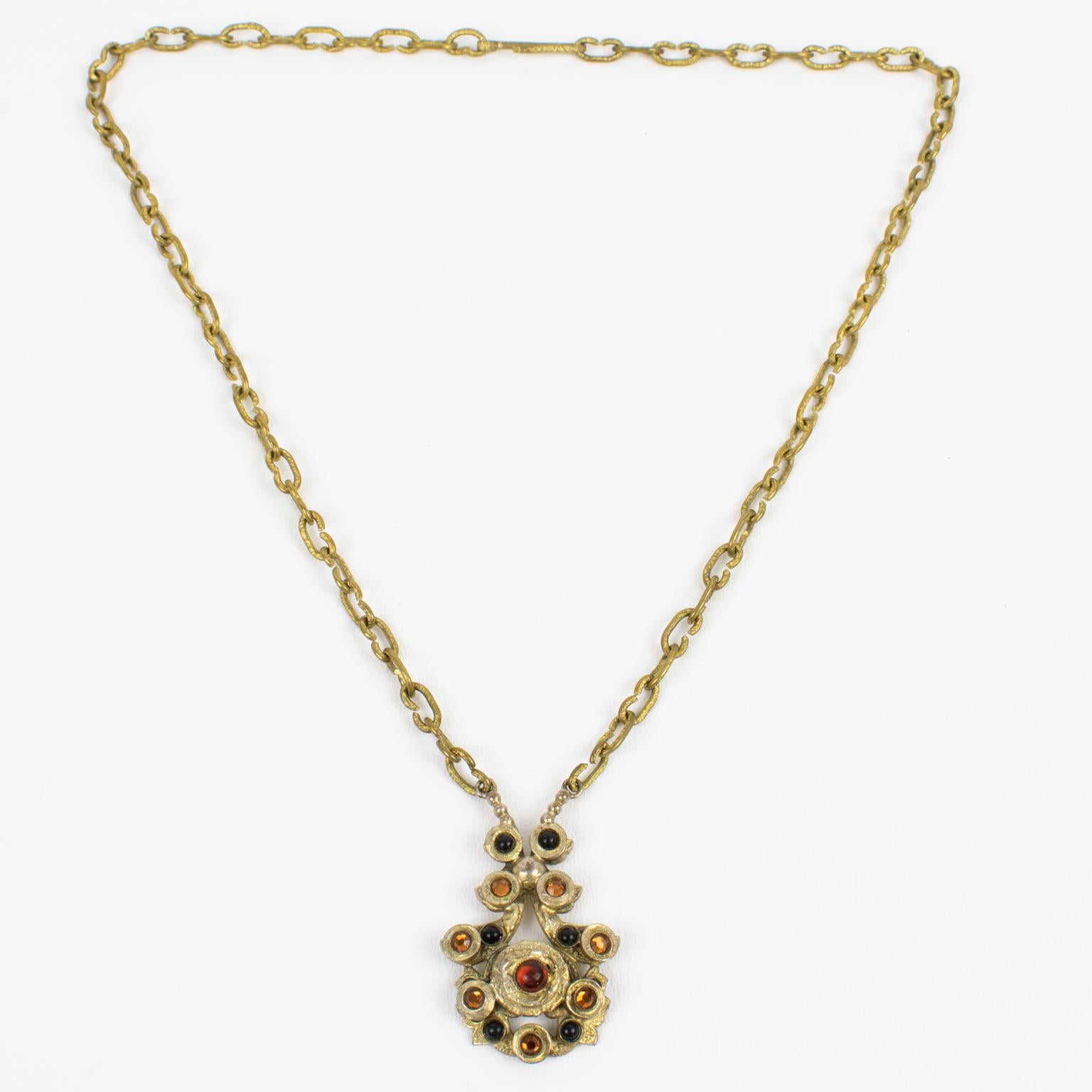 Henry Perichon (also known as renowned French designer Henry) designed this stunning Medieval Revival gilded bronze pendant necklace in the 1950s. The bronze metal pendant features an antique Middle Ages design influence and is ornate with black and