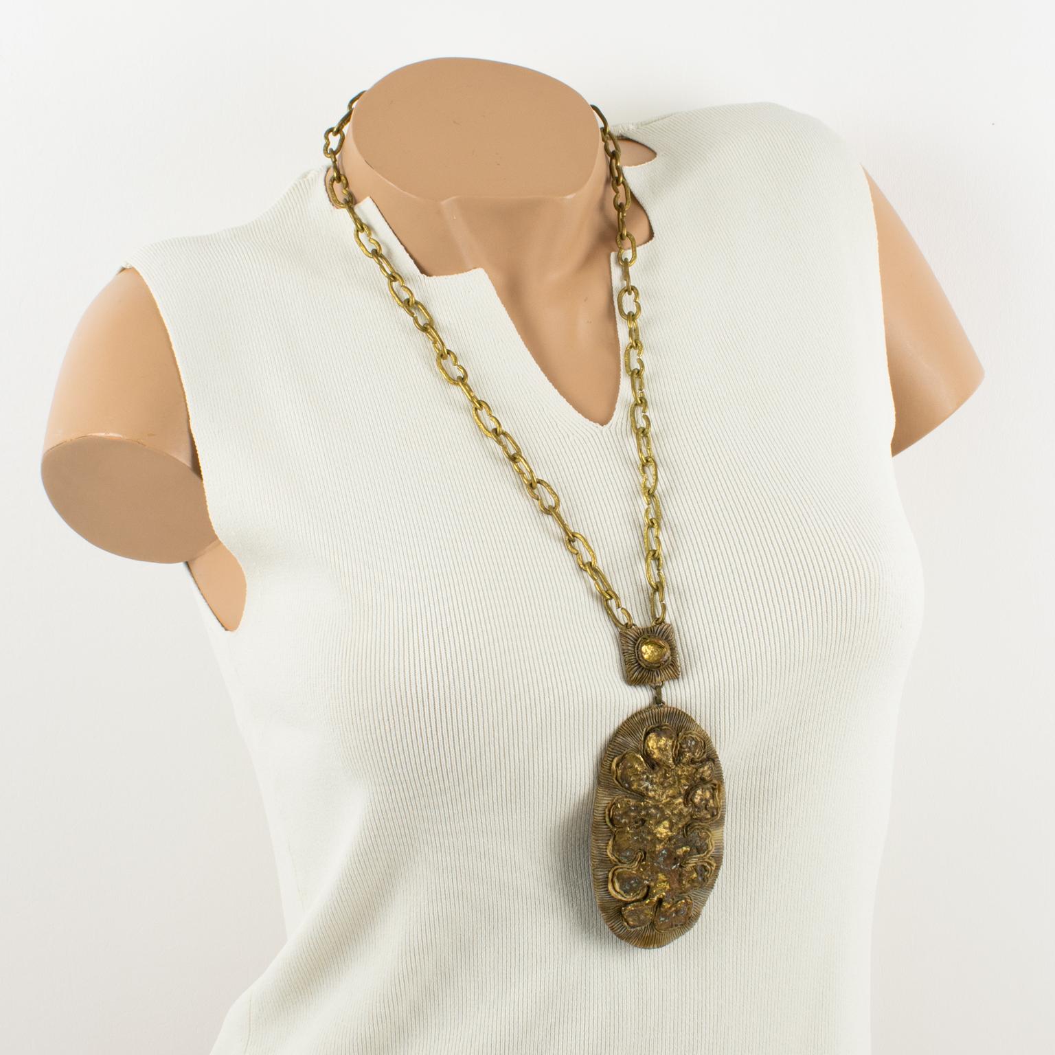 French jewelry artist Henry Perichon (aka Henry) designed this unique Talosel and bronze pendant necklace in the 1960s. The piece features a worked gilded heavy chain complimented with a brown-beige Talosel resin oval pendant. The central medallion