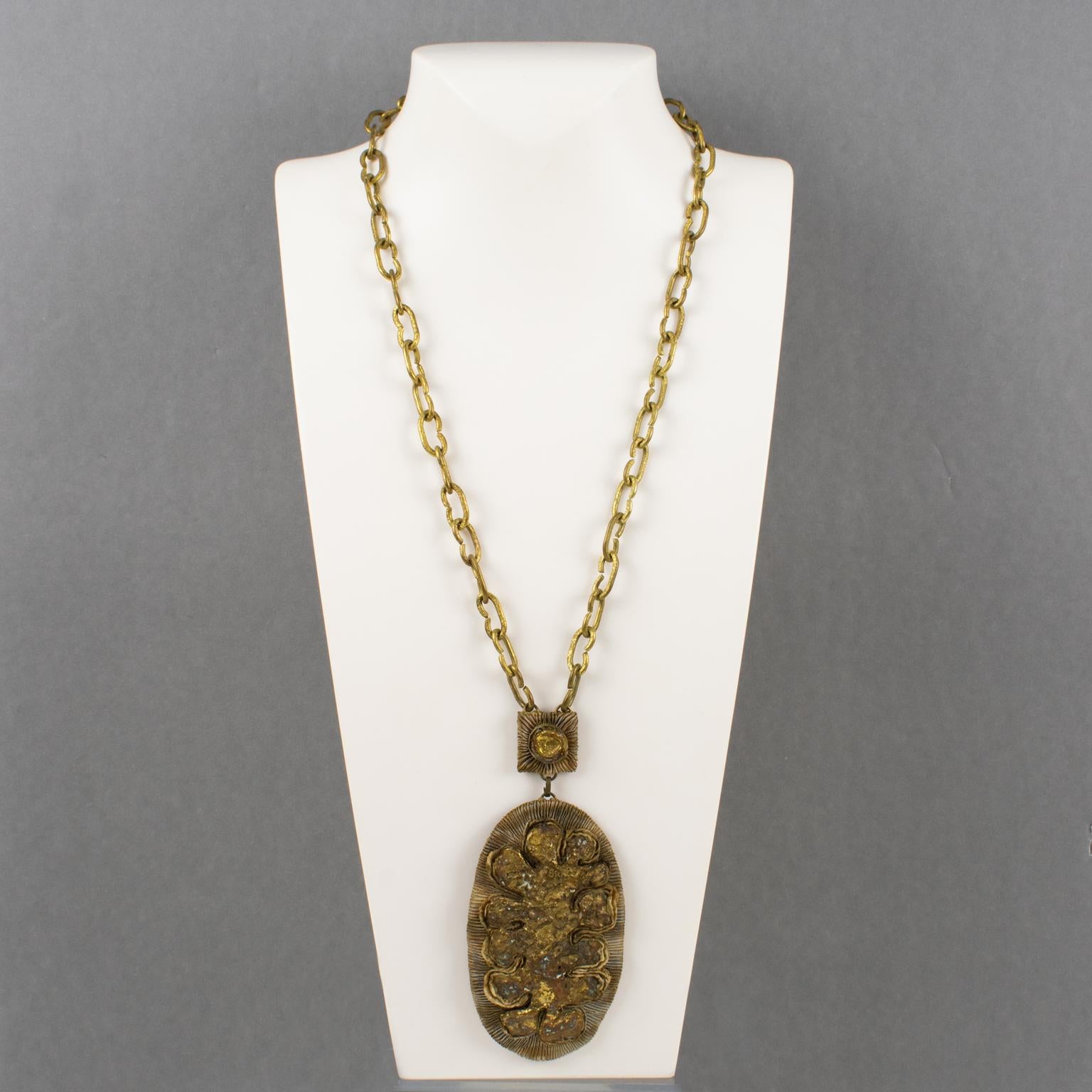 L'artiste joaillier français Henry Perichon (alias Henry) a conçu ce collier unique en talosel et en bronze dans les années 1960. La pièce comporte une chaîne lourde dorée et travaillée, complétée par un pendentif ovale en résine Talosel de couleur