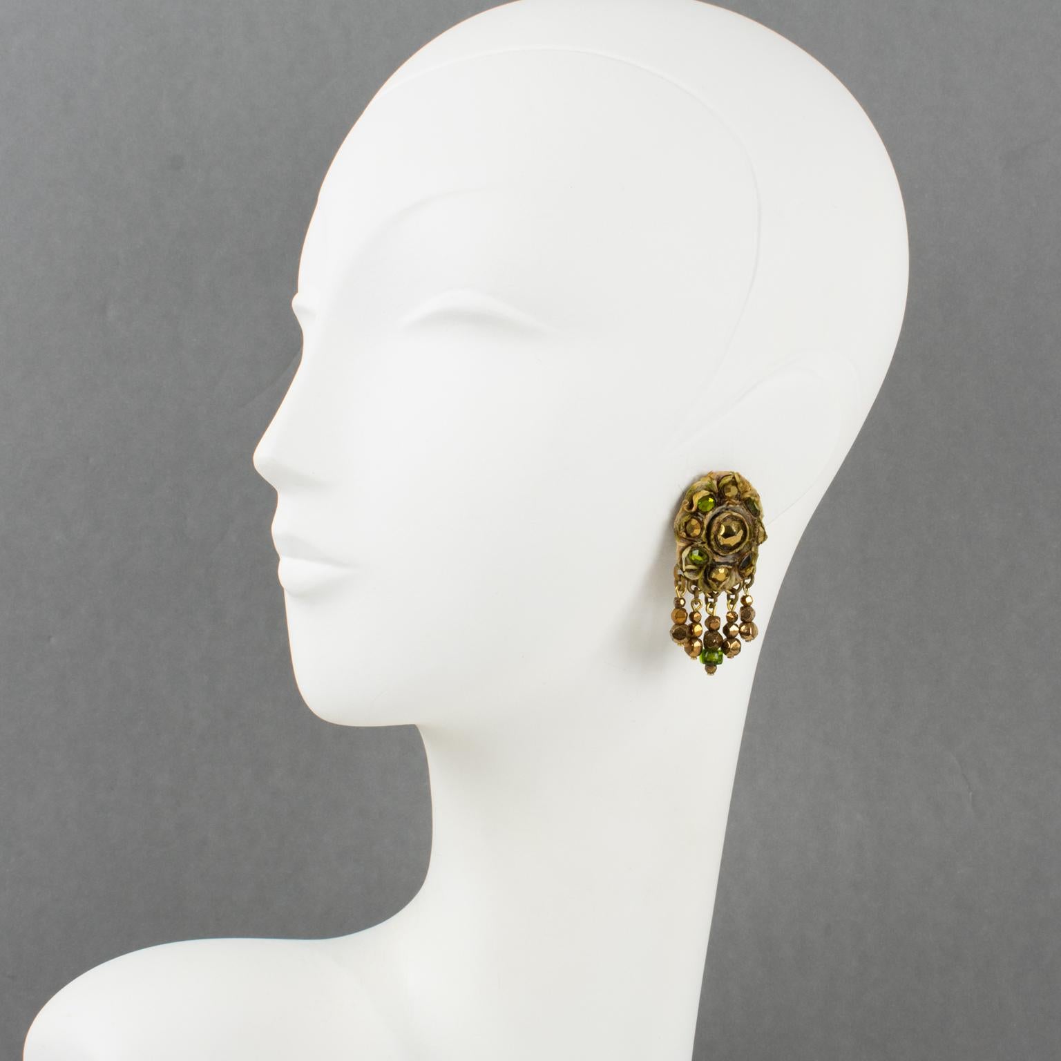 French jewelry artist Henry Perichon (aka Henry) designed these stunning Talosel resin clip-on earrings in the 1960s. They feature a brown-beige Talosel resin framing topped with metallic bronze and green glass faceted cabochons and complimented