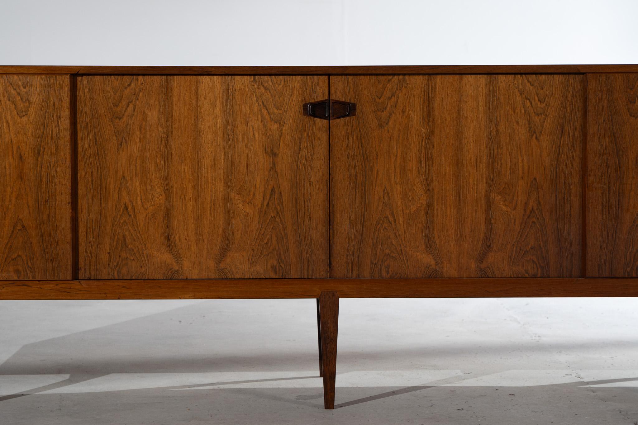 Questa credenza in palissandro di Henry Rosengren Hansen è un raffinato esempio di design danese del Mid-Century Modern, prodotto da Brande Møbelindustri. Il pezzo si distingue per le proporzioni equilibrate, i materiali di alta qualità e la