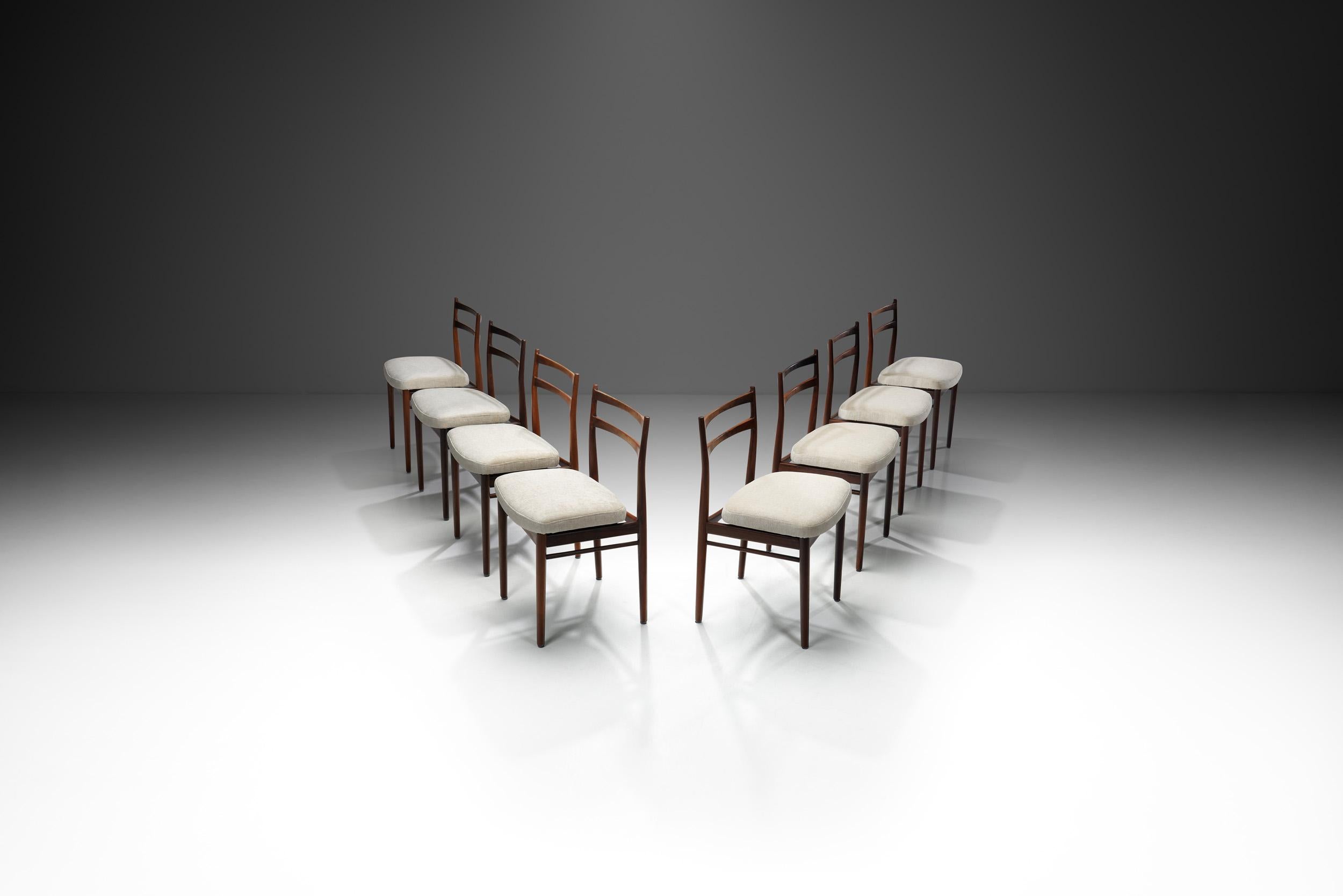 This set of eight dining chairs was crafted by esteemed Danish designer Henry Rosengren Hansen, considered one of the most influential cabinetmakers of the 20th century. After studying at the Royal Danish Academy of Fine Arts, he worked at the