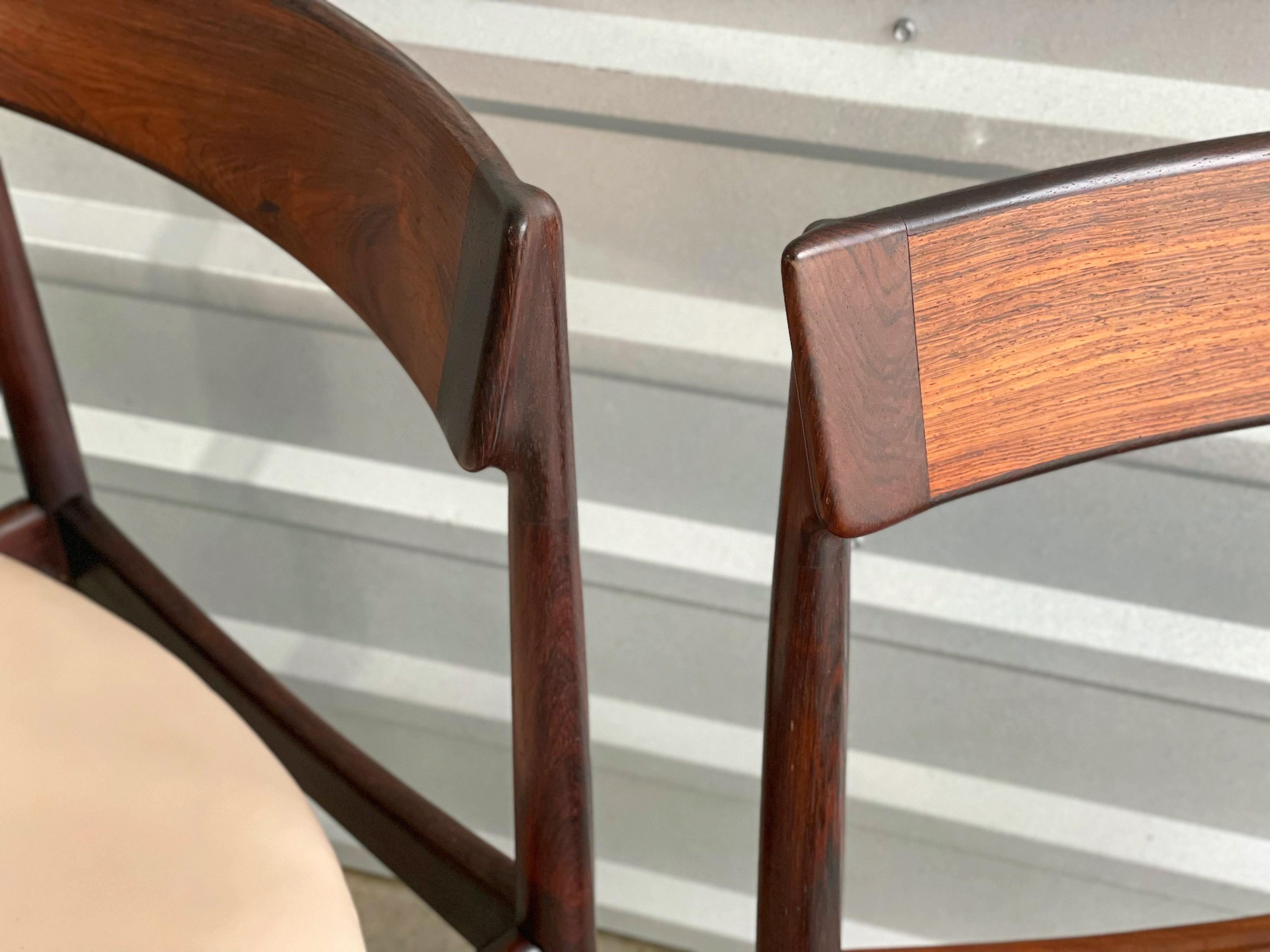 Two midcentury Danish modern Model 39 dining chairs in rosewood and wenge by Henry Rosengren Hansen for Brande Mobelfabrik. These particular examples were sold in Denmark by Illums Bolighus. Both chairs retain the original Illums Bolighus