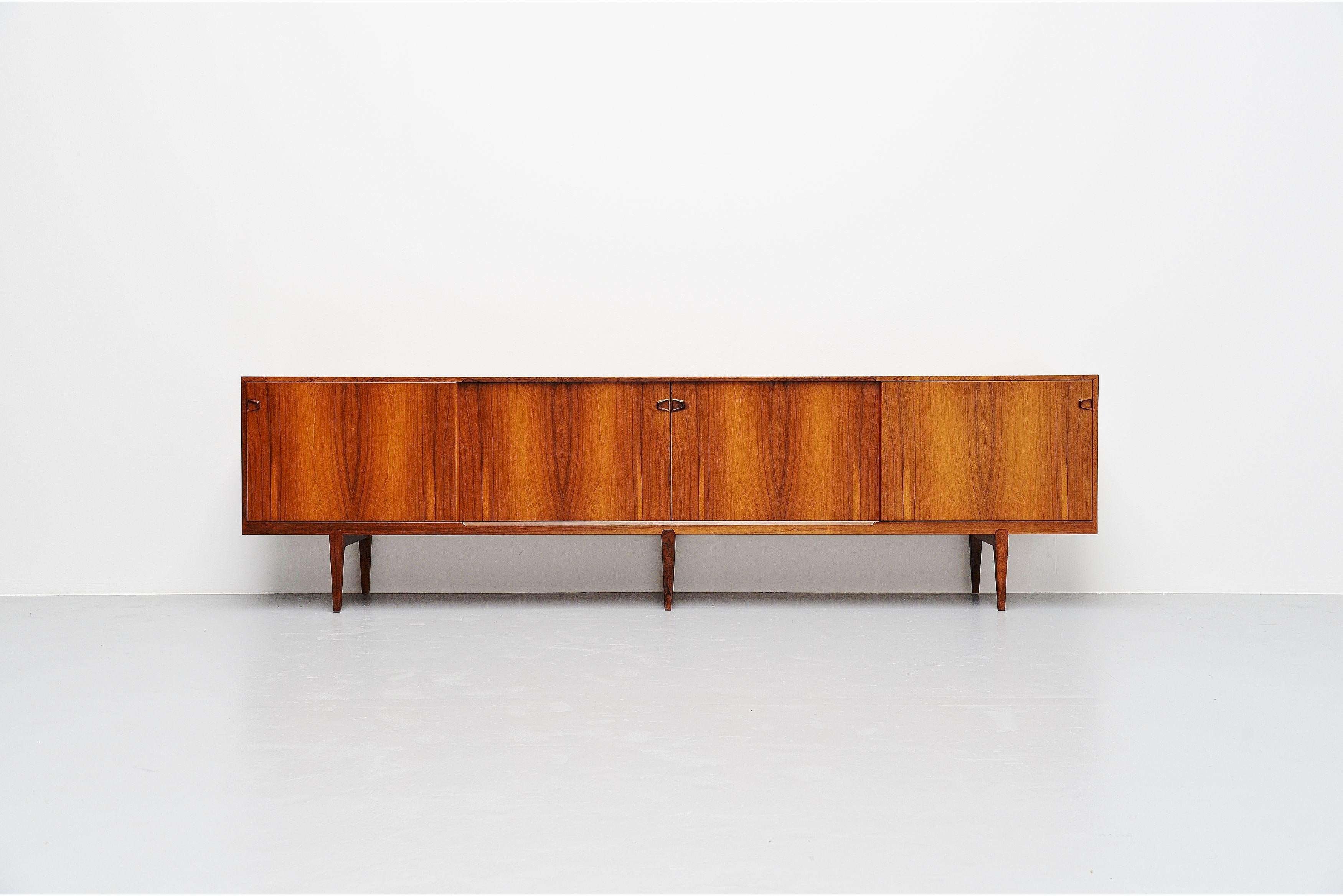 Highly refined rosewood sideboard model 9940 designed by Henry Rosengren Hansen for Rosengren Hansen, Denmark 1960. The sideboard has 4 sliding doors with 2 shelves and 8 drawers behind them. Very nice crafted sculptural handles and a nice detail is